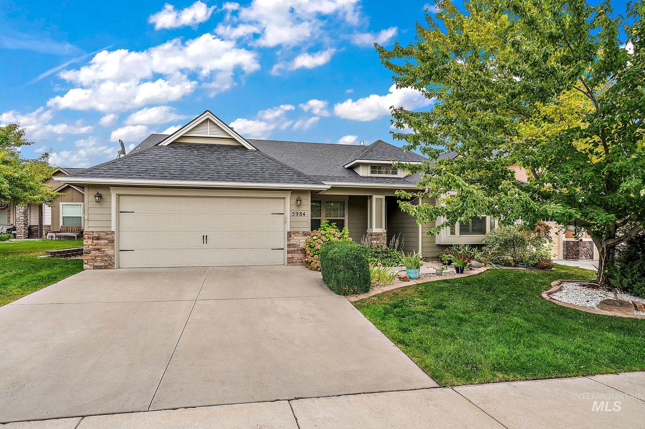 Craftsman inspired home featuring stone siding, a front yard, and a shingled roof