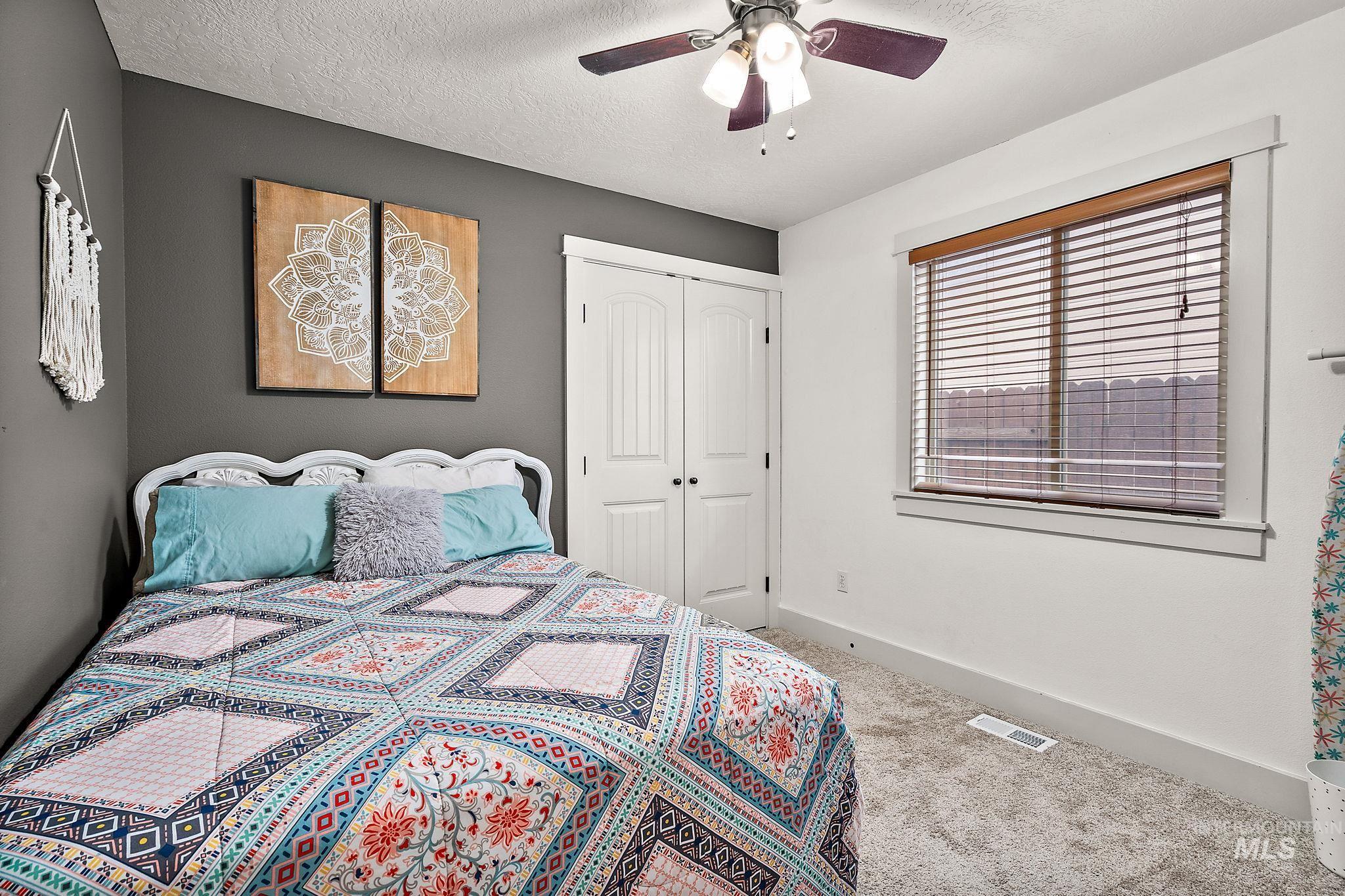 Bedroom with carpet, a textured ceiling, ceiling fan, and a closet