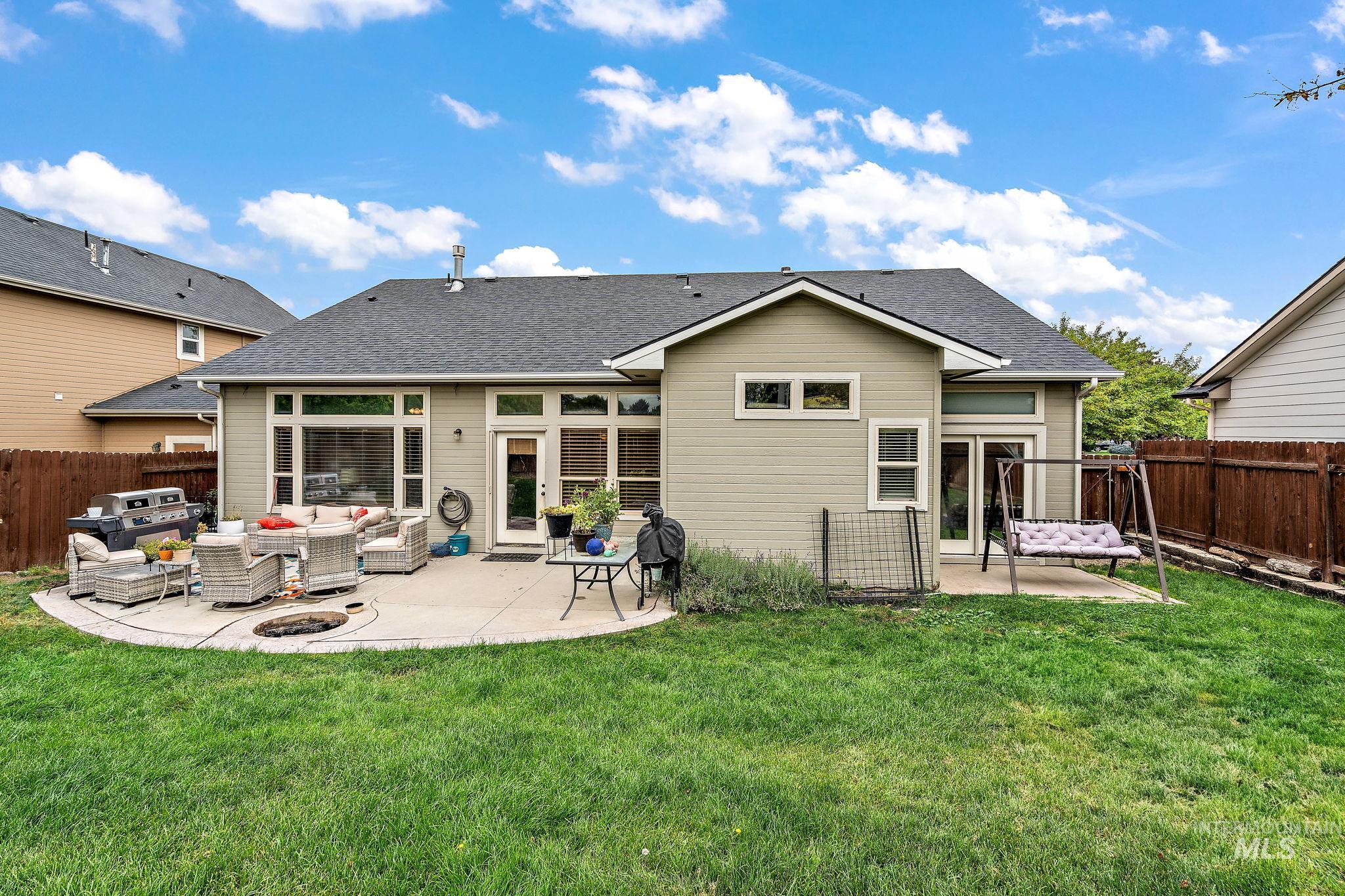 Back of property featuring an outdoor living space, a fenced backyard, a patio area, and a shingled roof