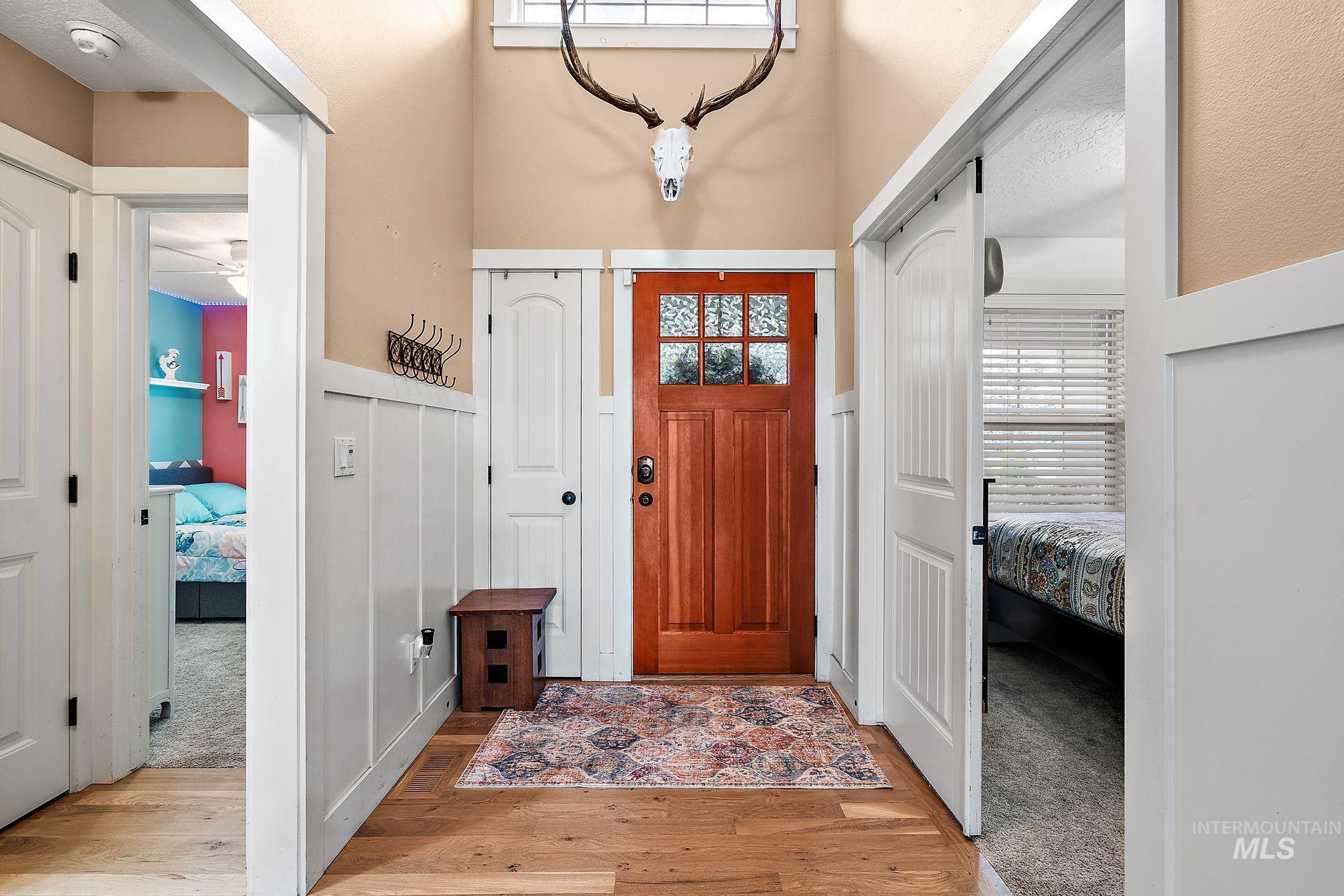 Foyer featuring light wood finished floors and wainscoting