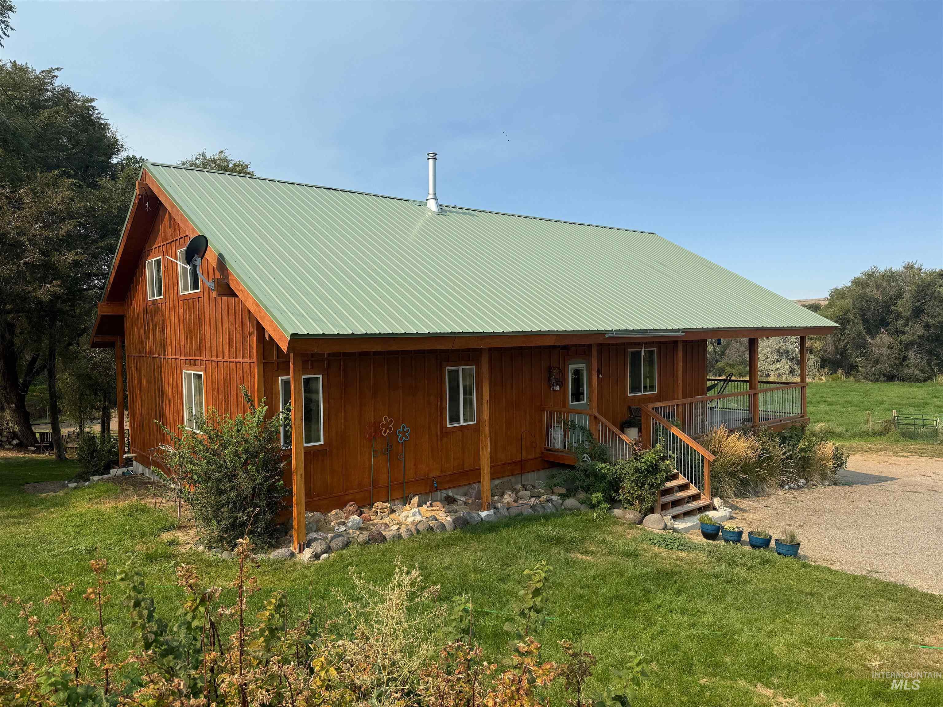 Back of house featuring a porch, a metal roof, and a lawn