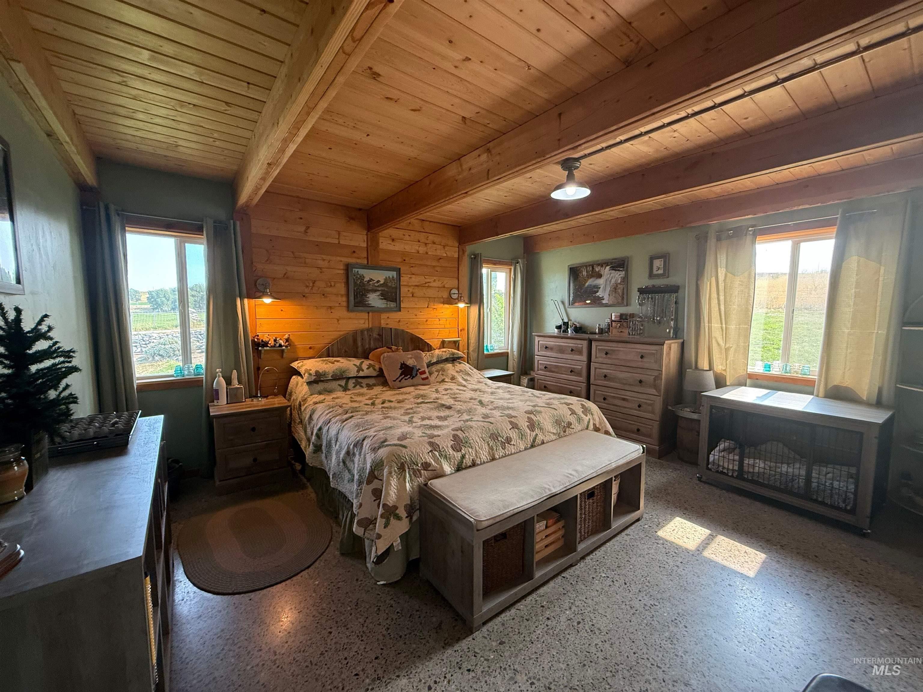 Bedroom featuring wood walls and a wood ceiling with exposed beams