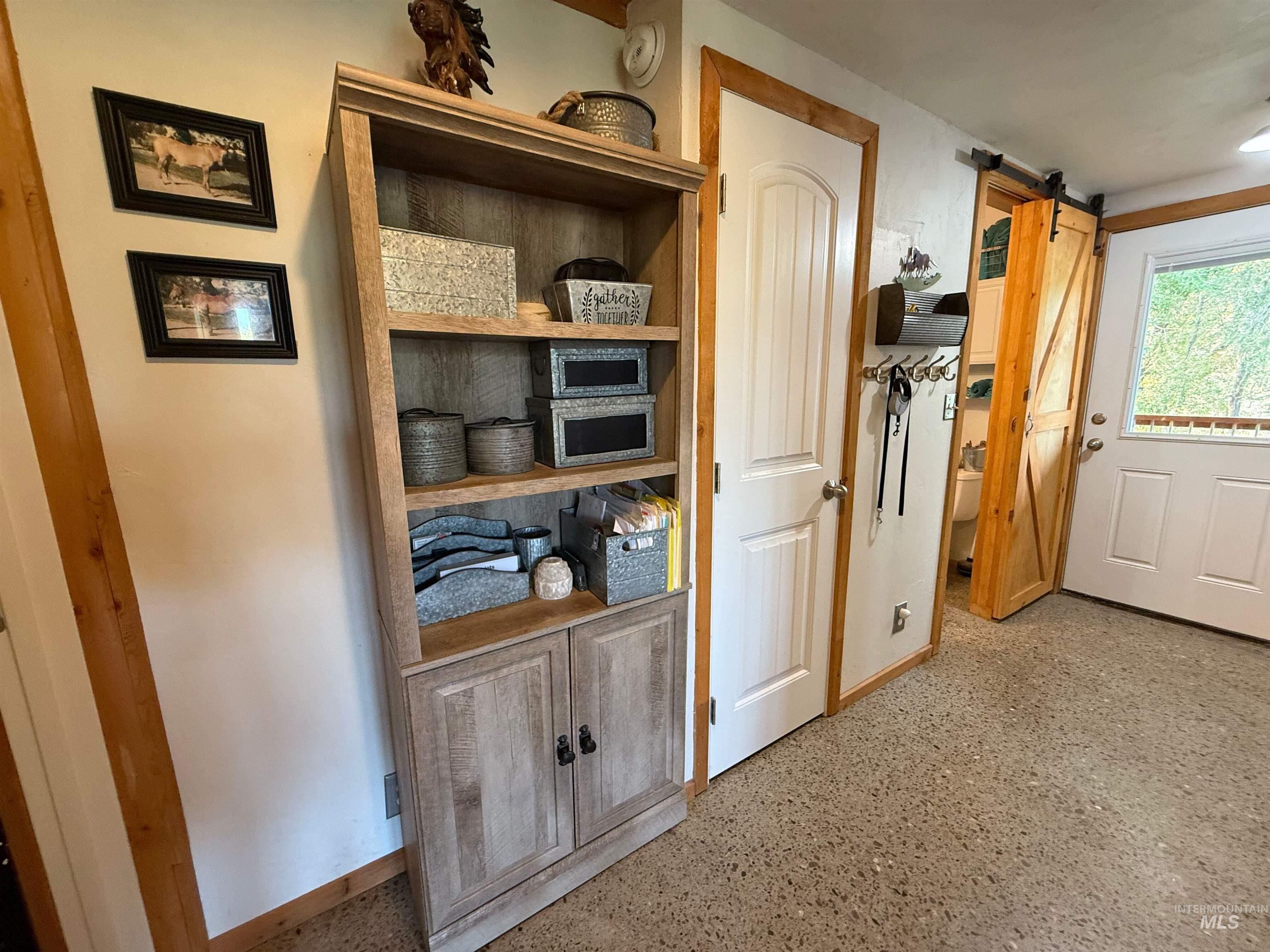 Hallway with a barn door and dark speckled floor