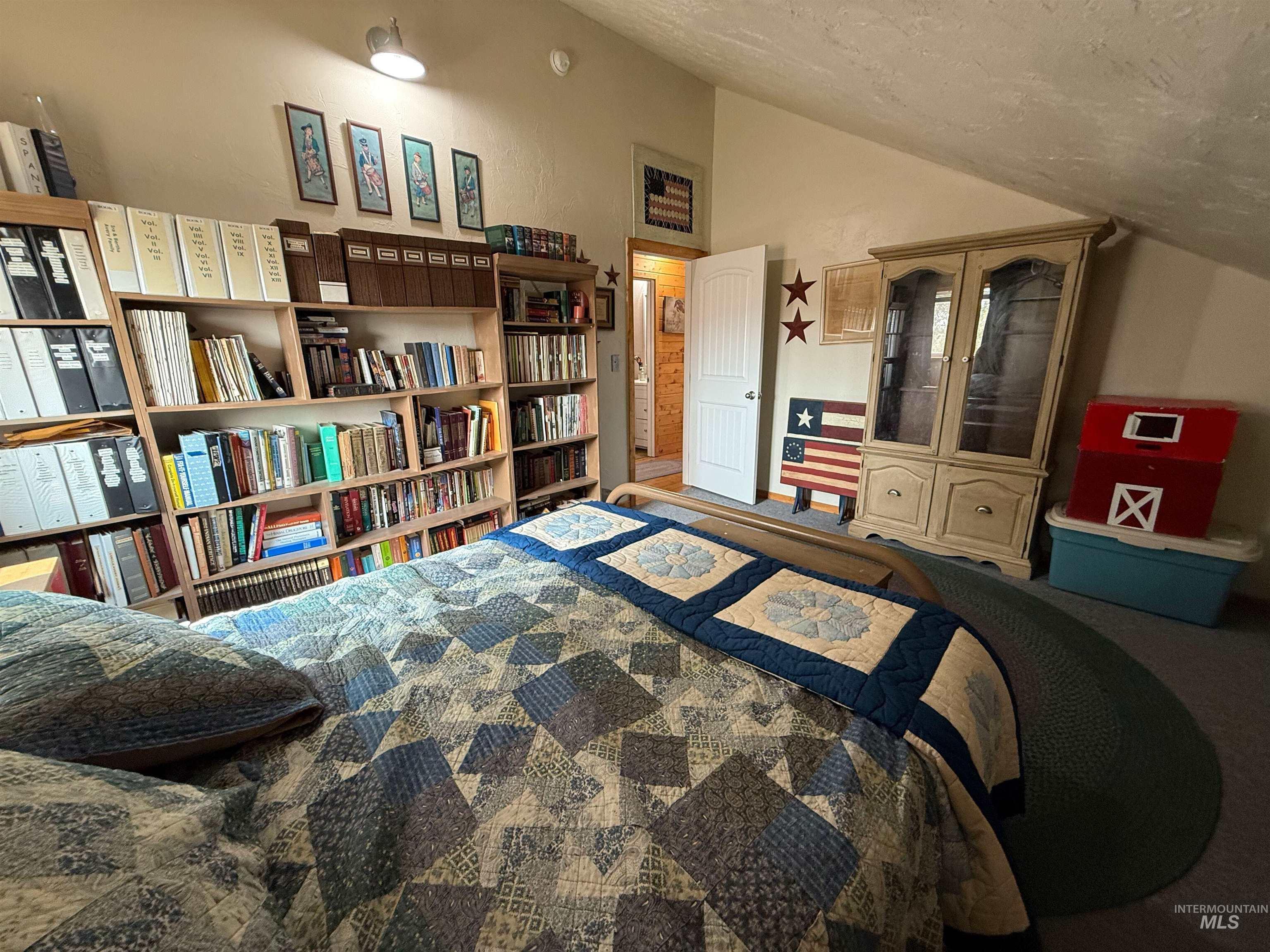 Carpeted bedroom featuring lofted ceiling and a textured ceiling