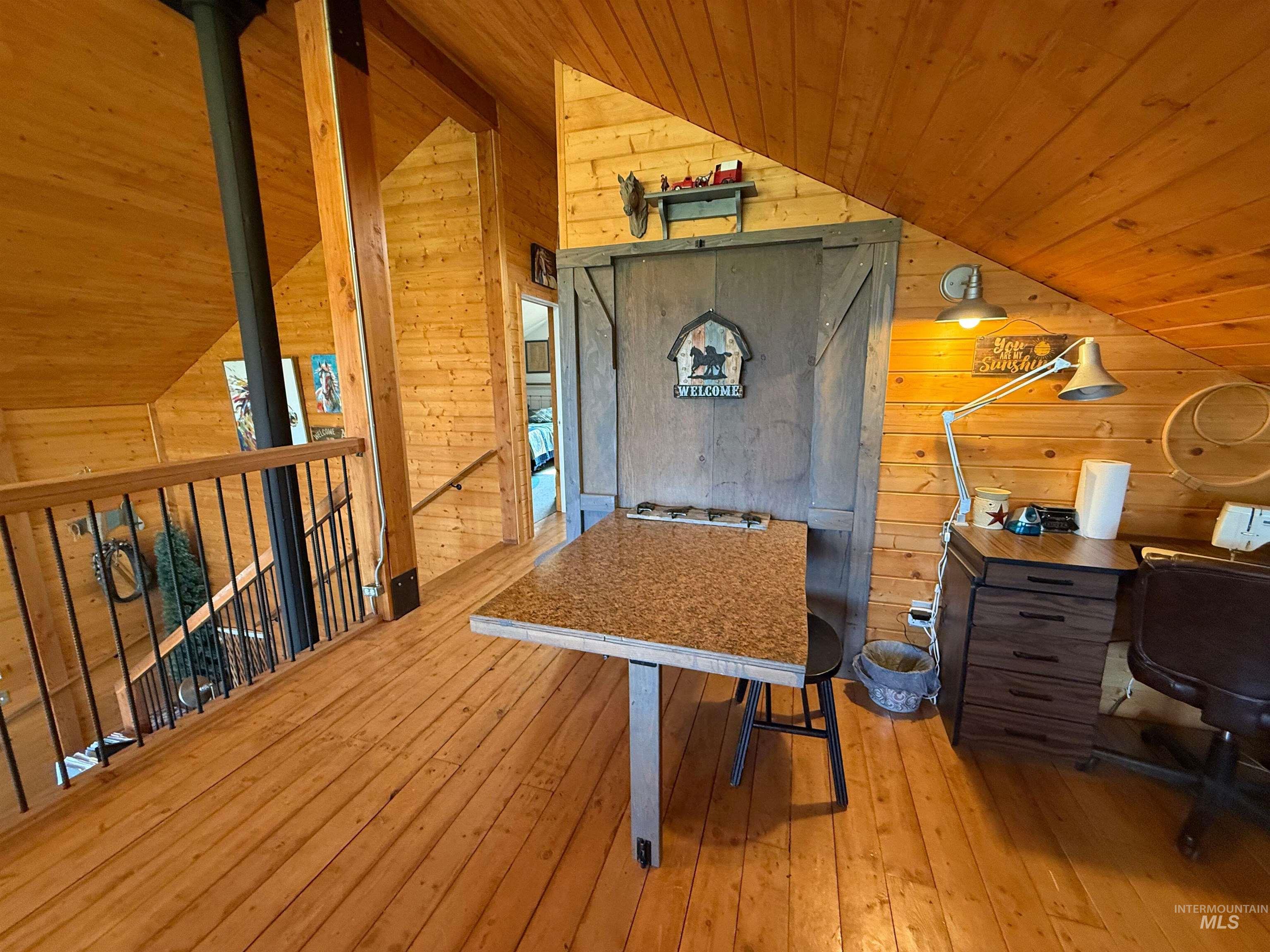 Office area with wood walls, lofted ceiling, wood ceiling, and light wood-style flooring