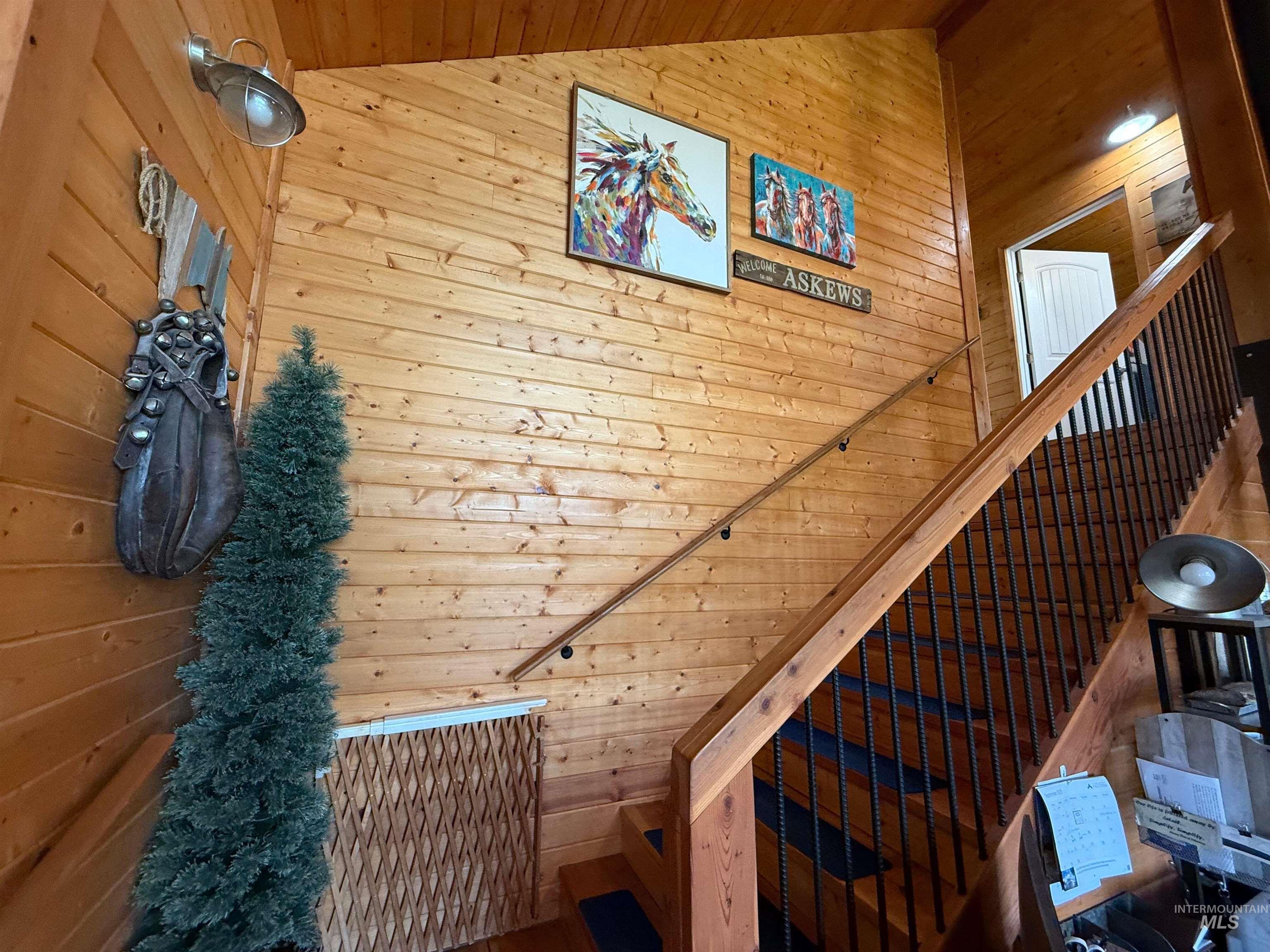 Staircase with wood walls, wooden ceiling, and lofted ceiling