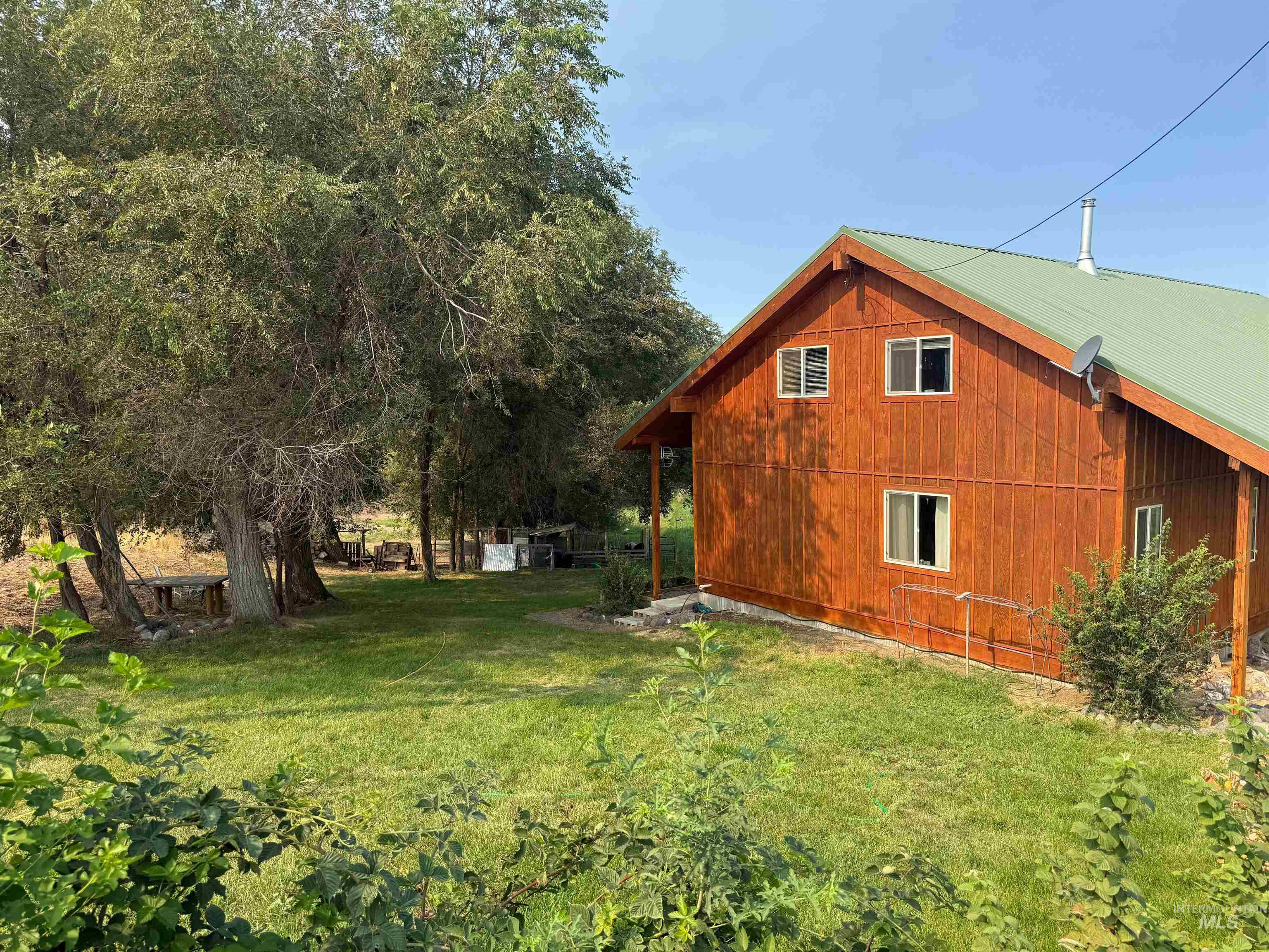 View of side of home with a lawn and a metal roof