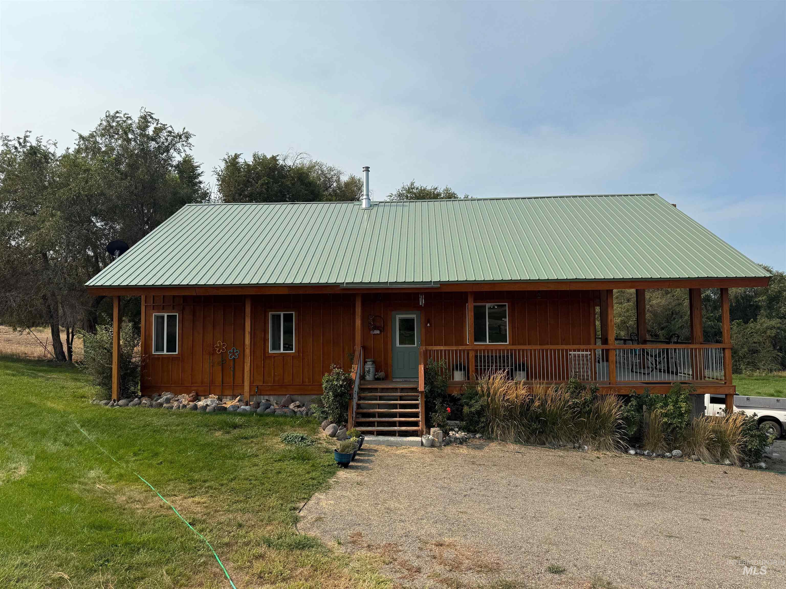 View of front of property featuring covered porch, a metal roof, and a front yard