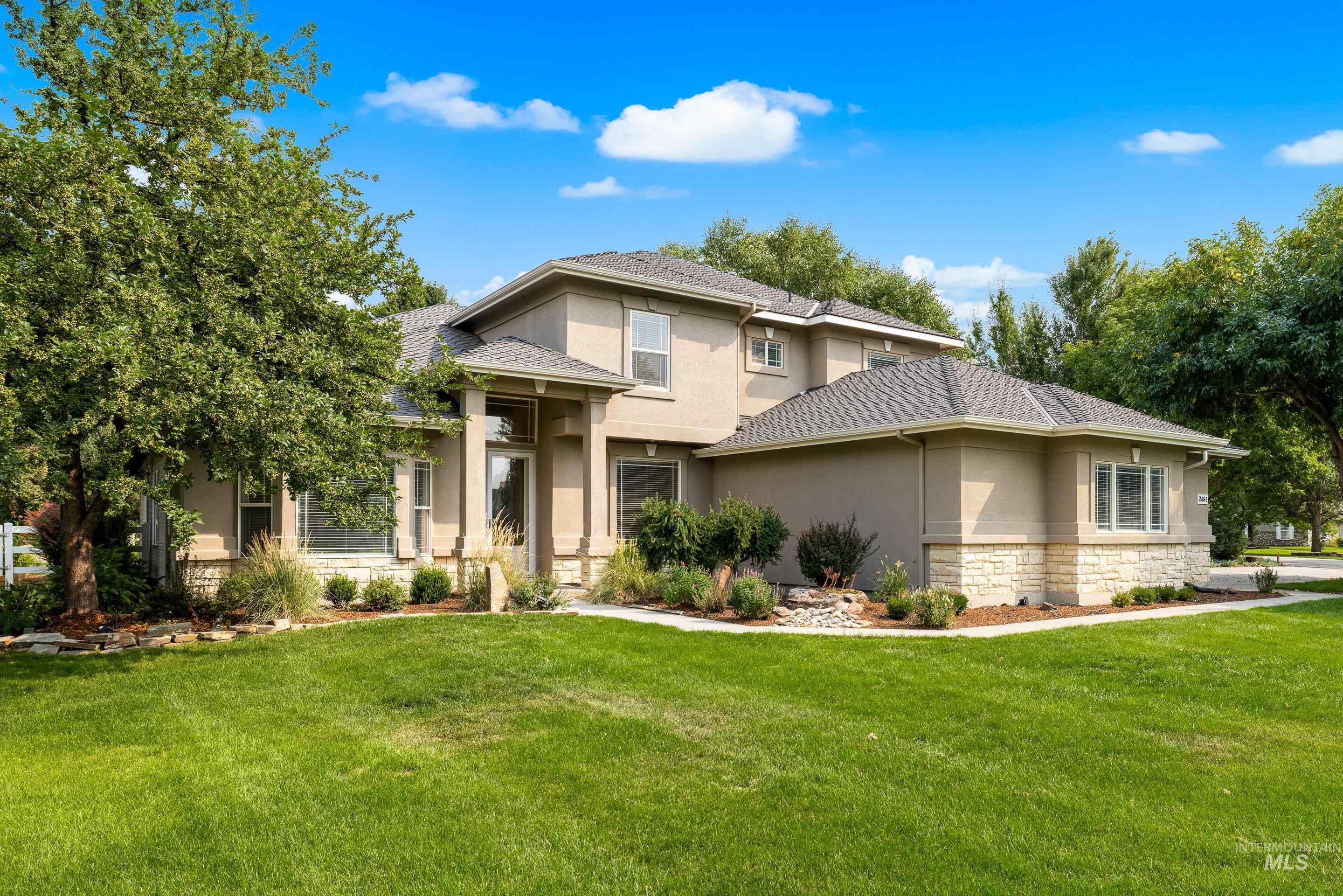 Prairie-style house with stone siding, stucco siding, and a front lawn