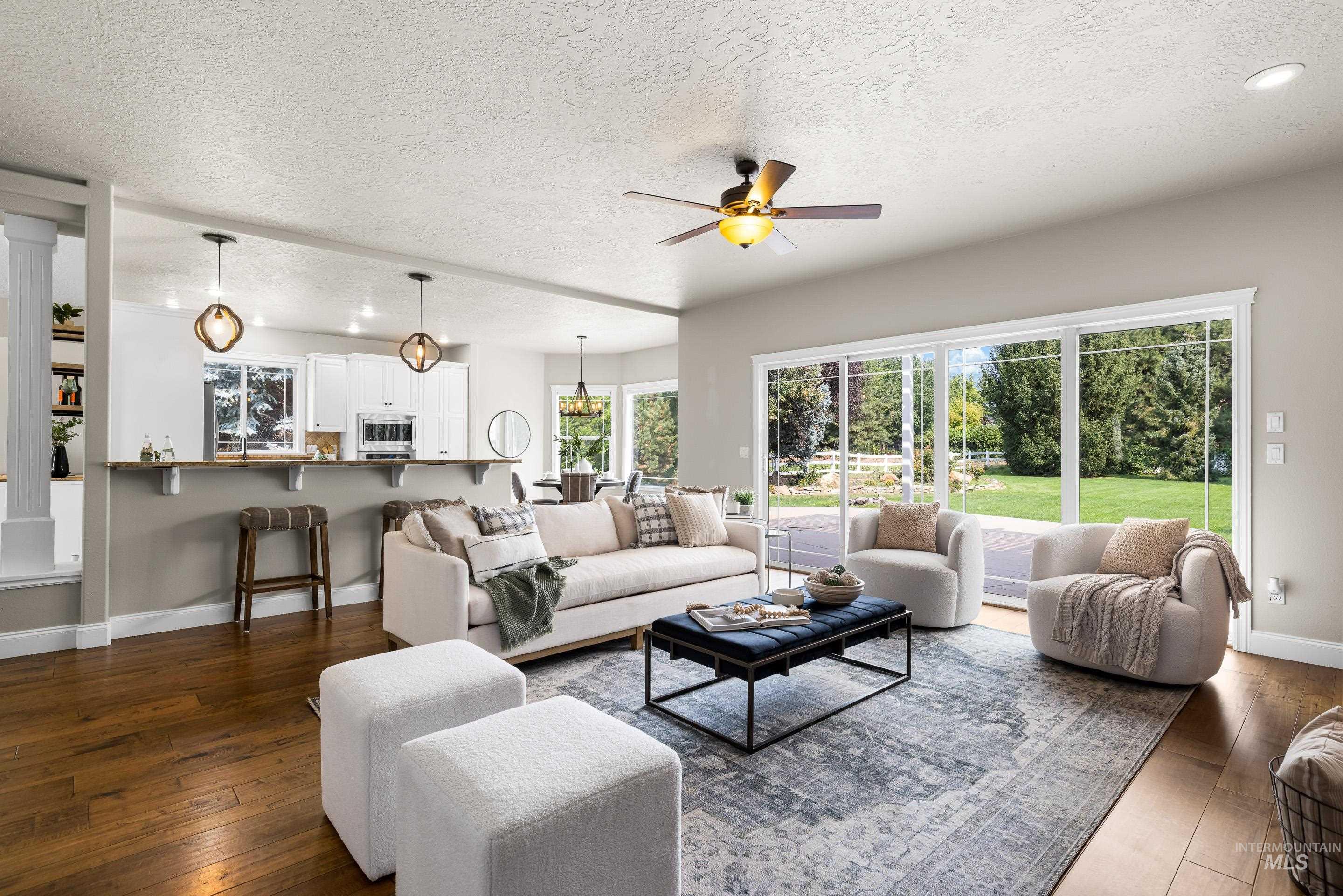 Living room featuring a textured ceiling, dark wood-type flooring, a ceiling fan, and recessed lighting