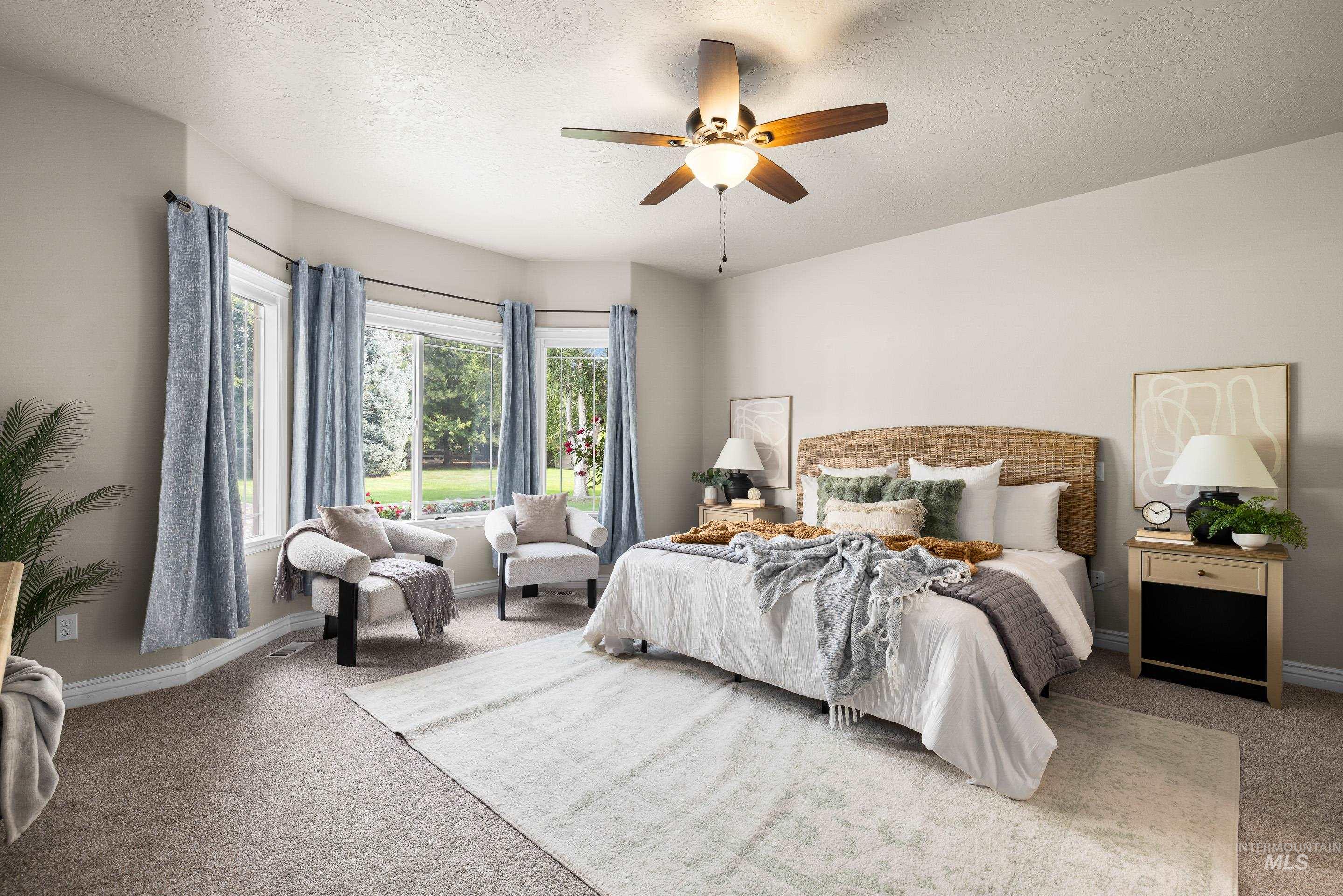 Carpeted bedroom featuring a textured ceiling and a ceiling fan