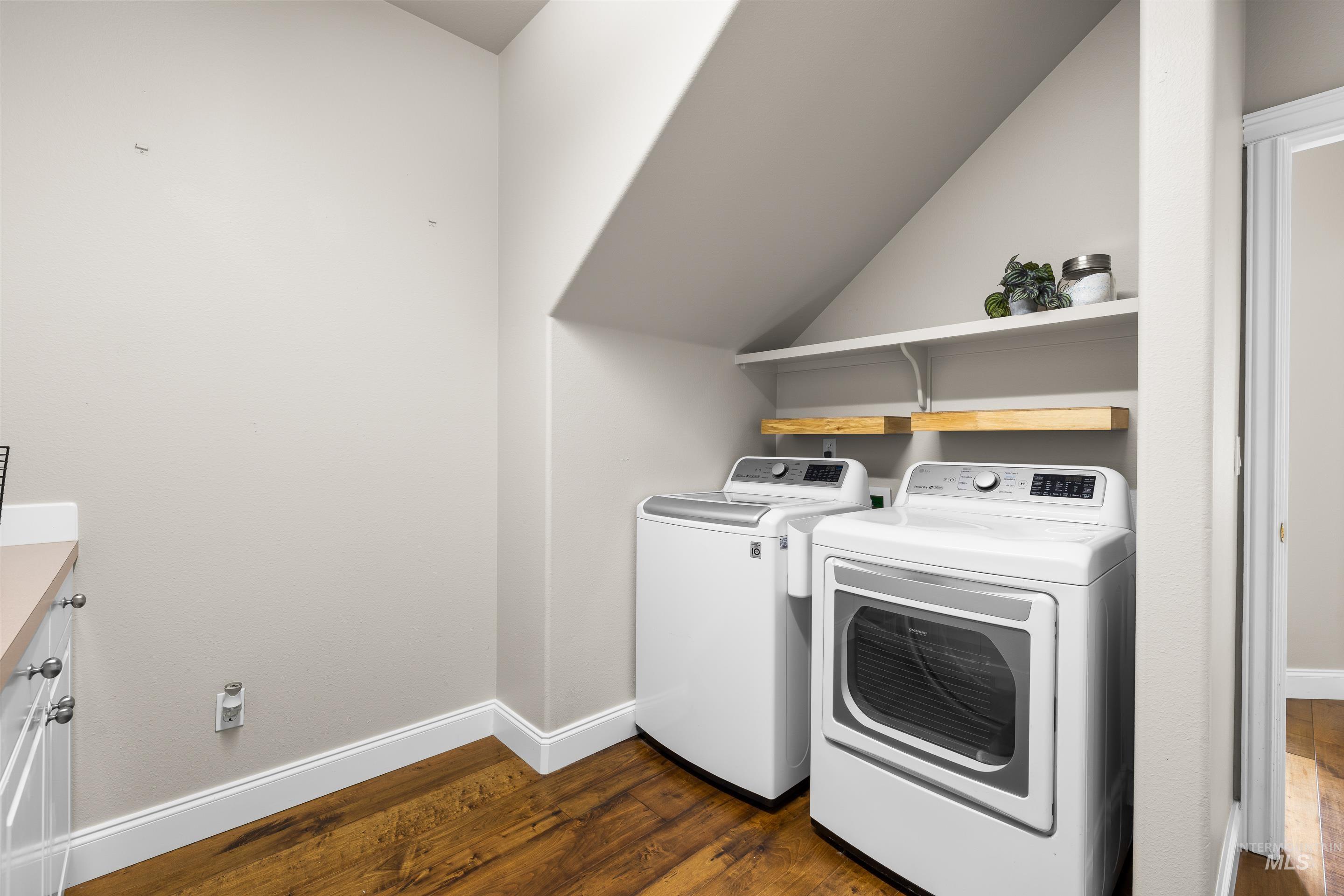 Laundry area with dark wood-style floors and independent washer and dryer