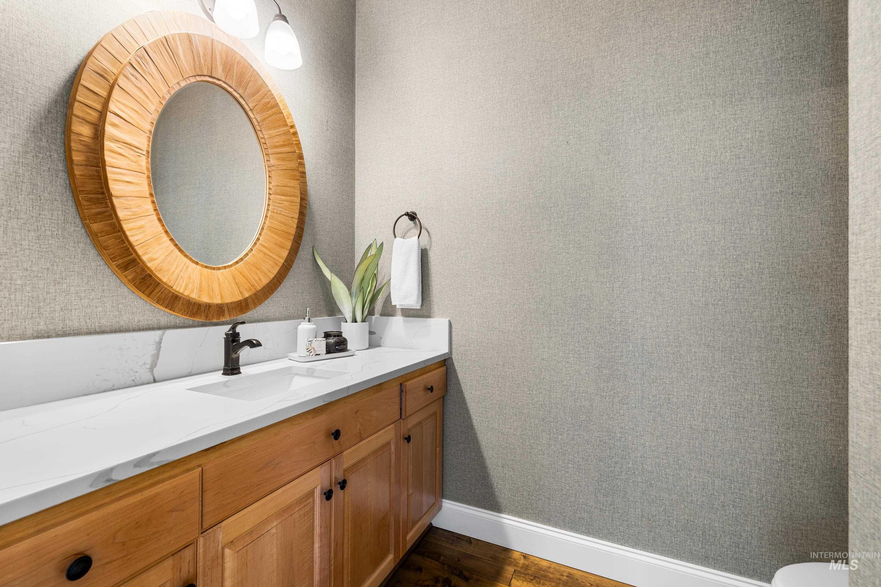 Bathroom featuring vanity, dark wood finished floors, and wallpapered walls