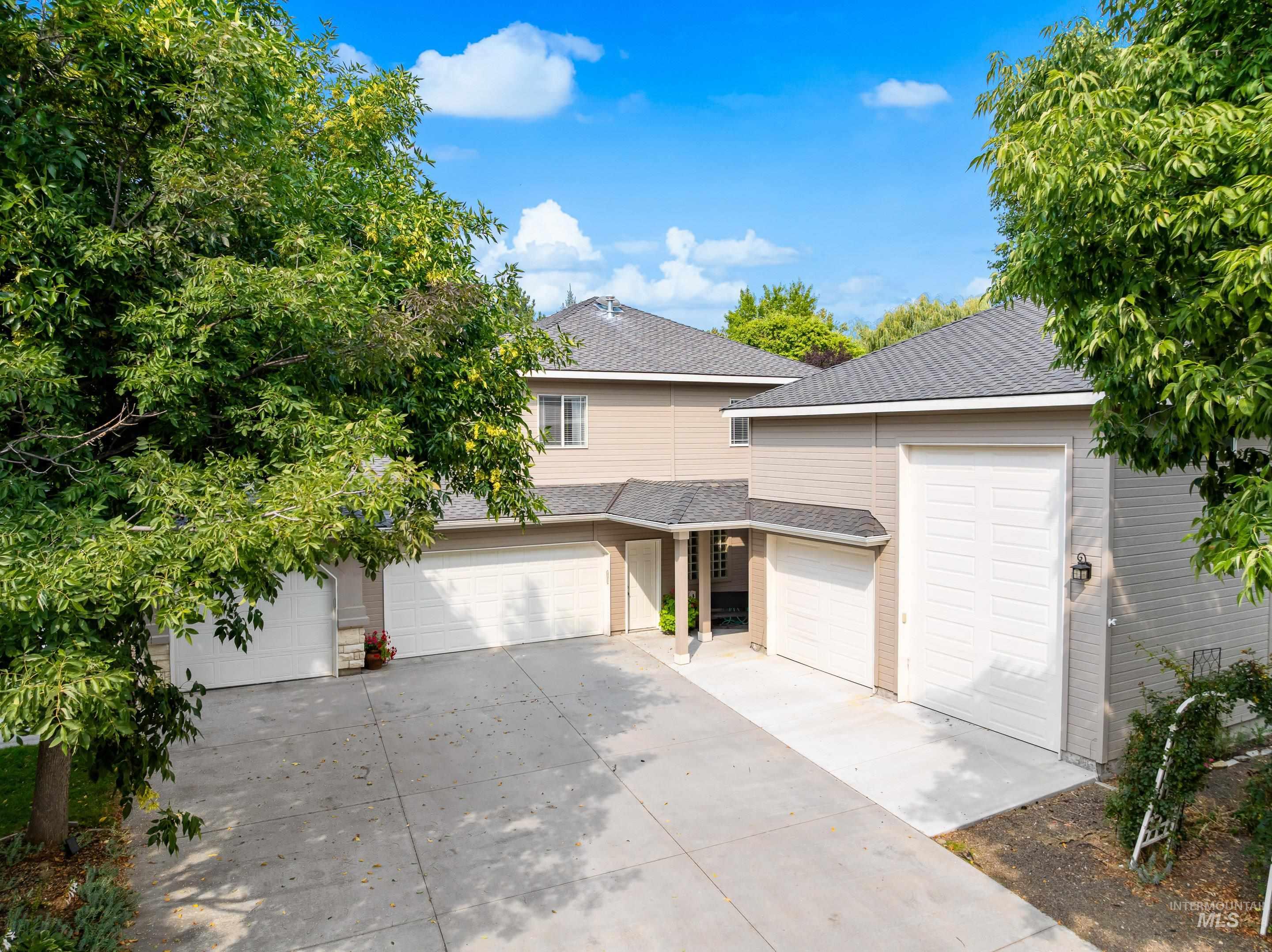 View of front facade featuring a garage, a shingled roof, and concrete driveway