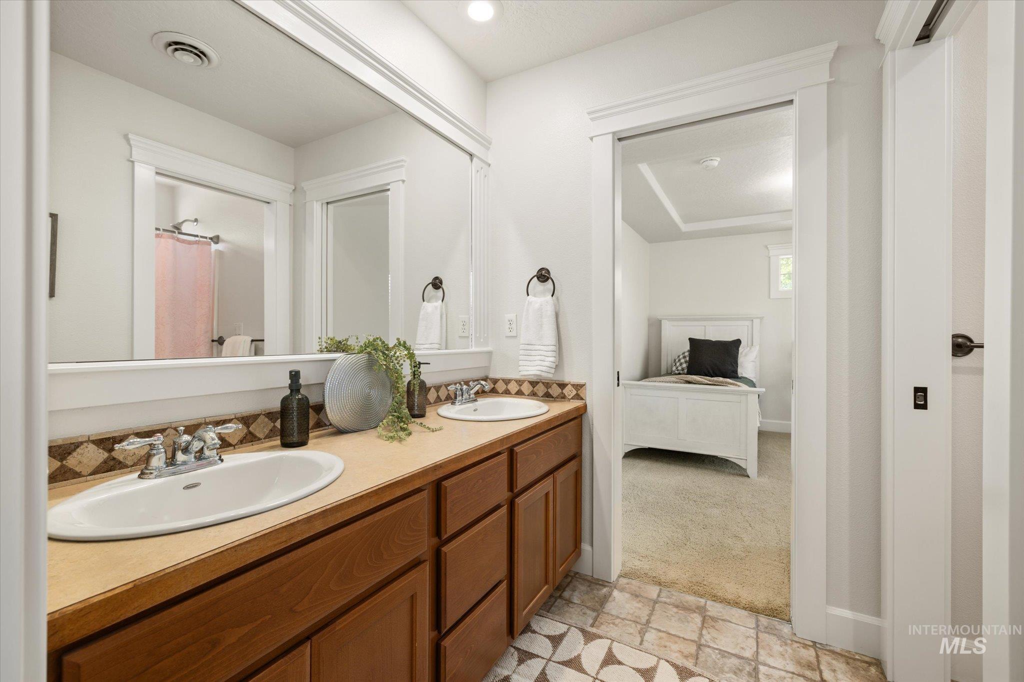 Full bathroom with double vanity, connected bathroom, a shower with shower curtain, and recessed lighting