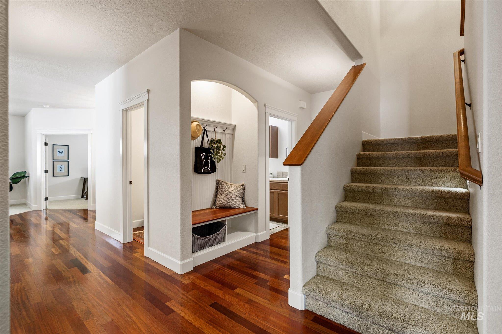 Staircase with wood finished floors and baseboards