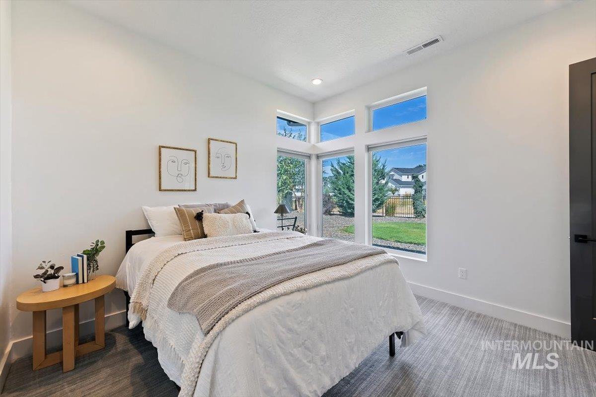 Carpeted bedroom featuring baseboards and a towering ceiling