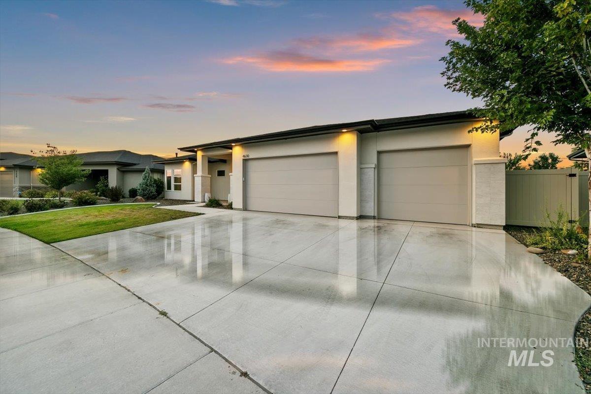 Prairie-style house with an attached garage, stucco siding, and driveway