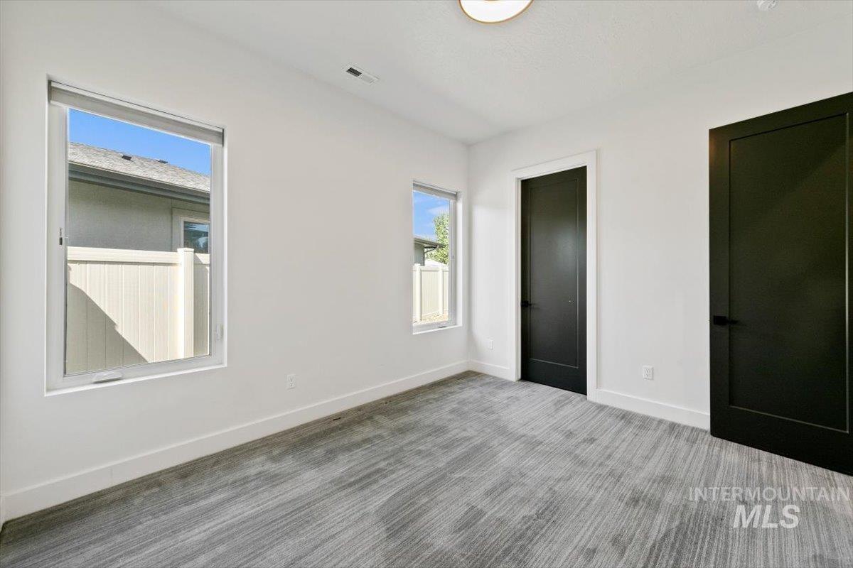 Unfurnished bedroom featuring carpet and multiple closets