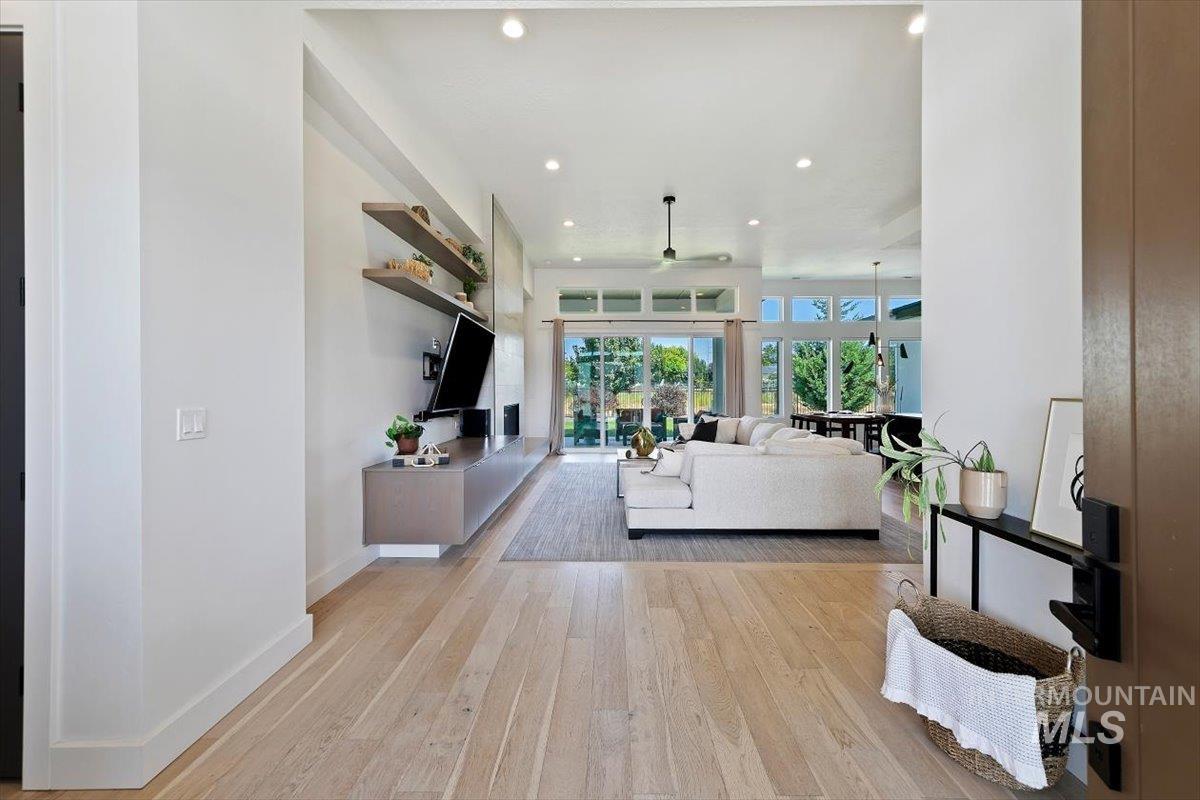 Living room with recessed lighting, light wood-style floors, and a ceiling fan