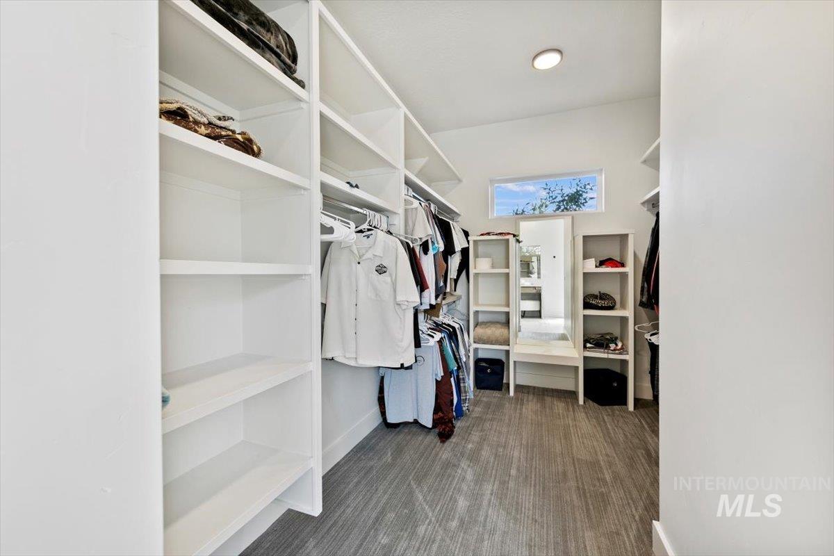 Walk in closet featuring dark carpet