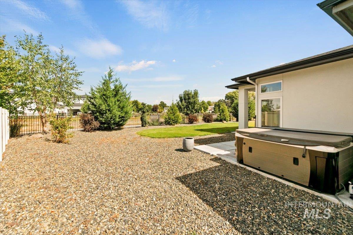 Fenced backyard with a hot tub and a patio area