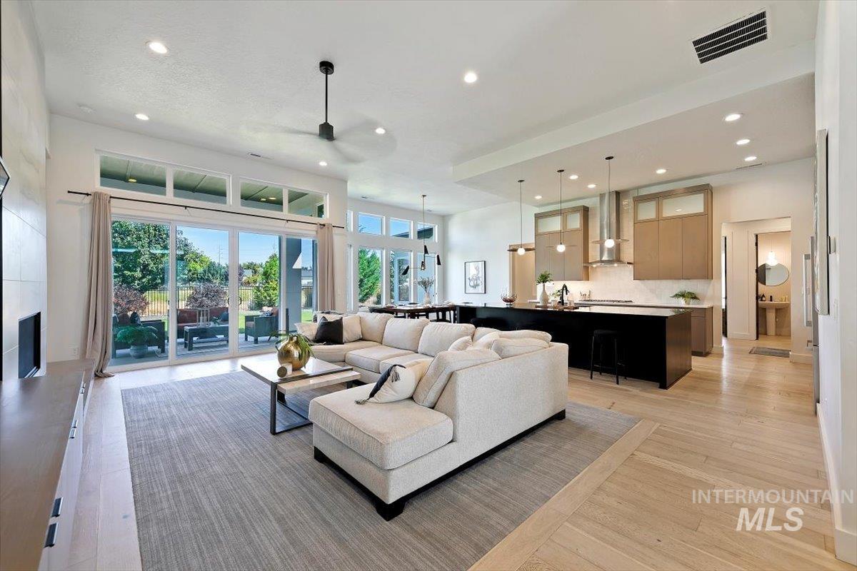 Living area with recessed lighting, light wood-style floors, ceiling fan, and a tile fireplace
