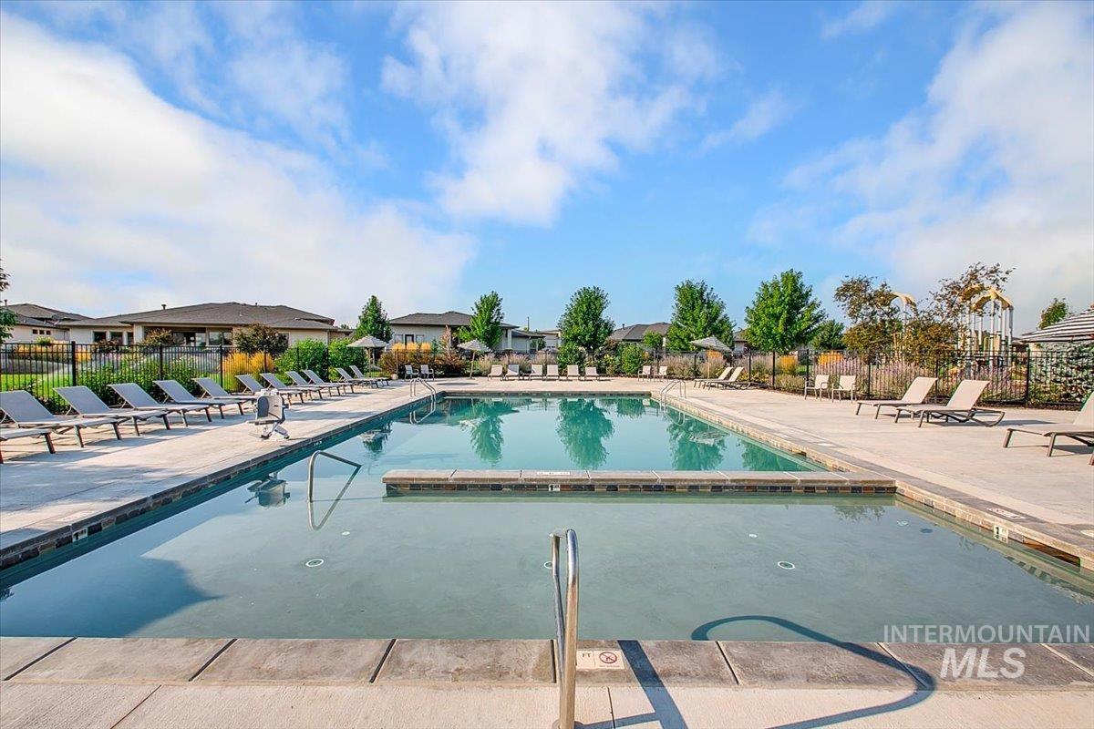Community pool with a patio and a residential view