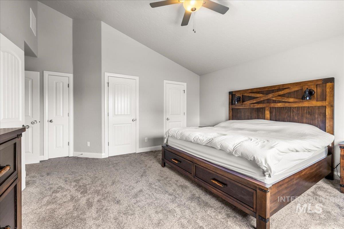 Bedroom featuring light colored carpet, high vaulted ceiling, and ceiling fan