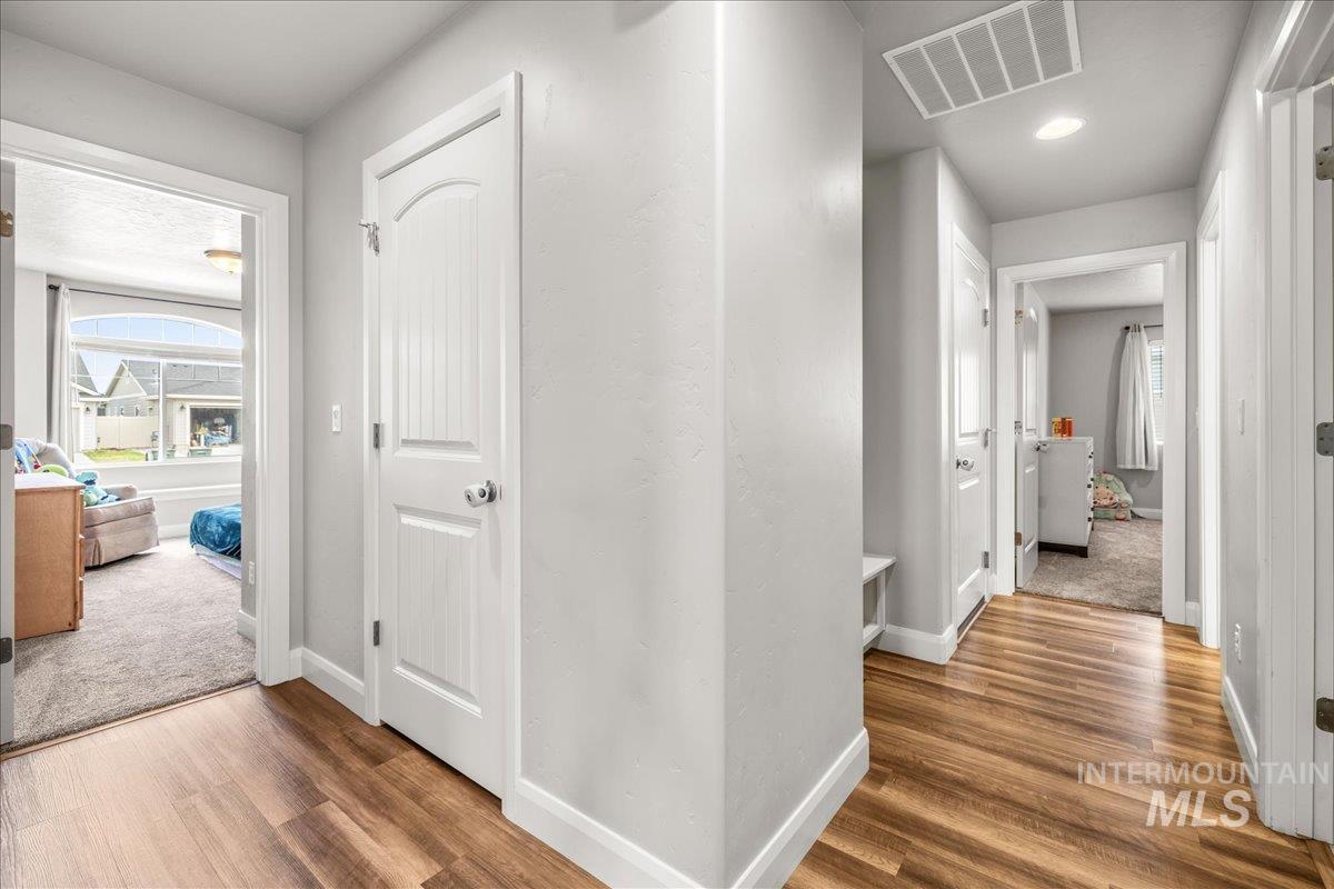 Hallway featuring plenty of natural light and wood finished floors