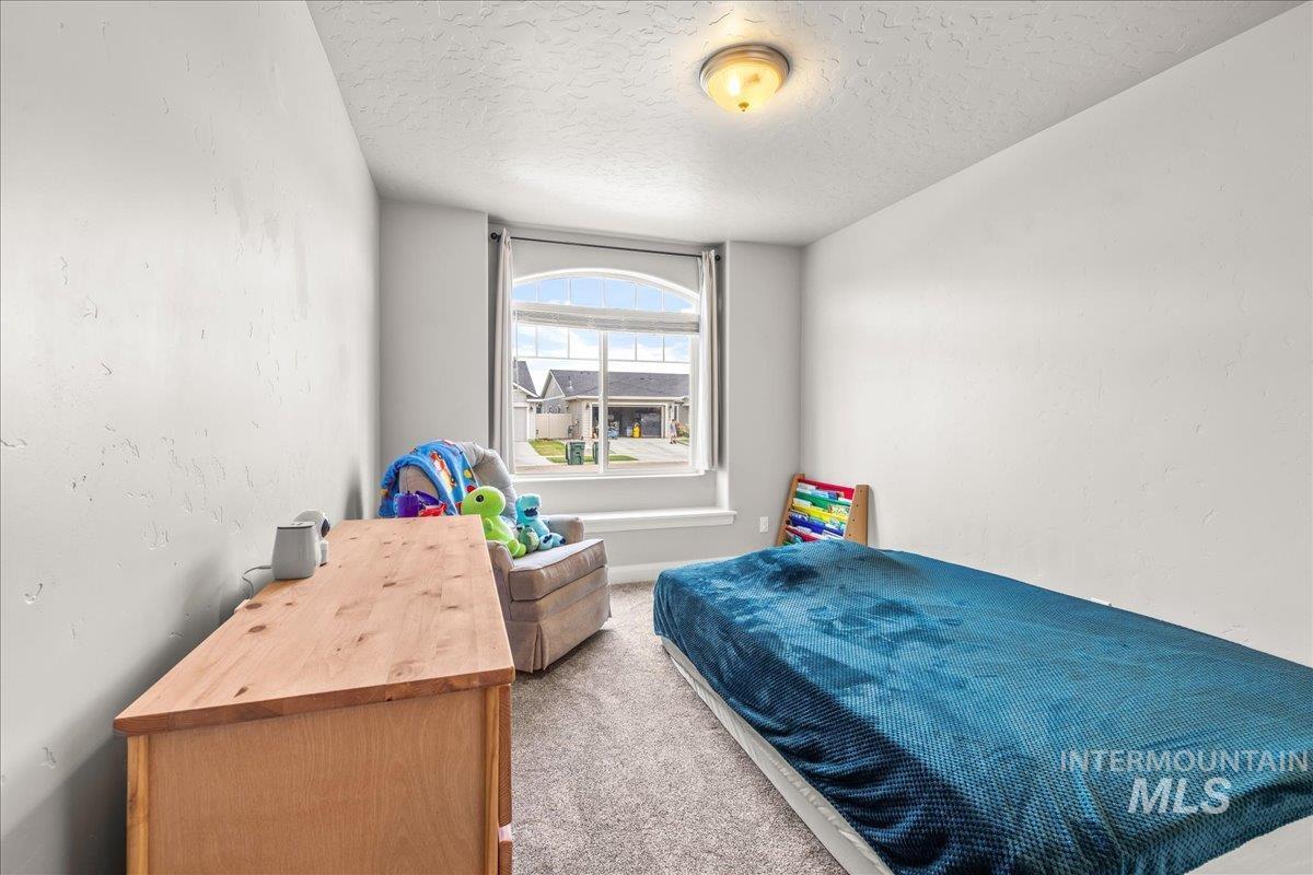 Carpeted bedroom with a textured ceiling