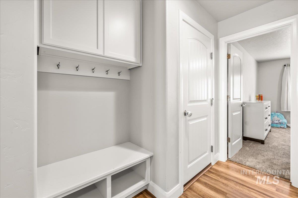 Mudroom with light wood-type flooring and baseboards