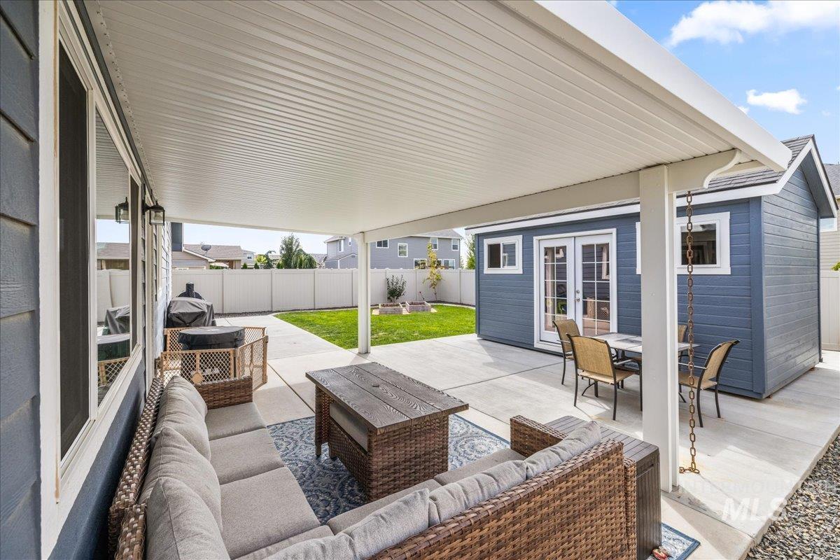 Fenced backyard with an outdoor living space, a patio area, and french doors