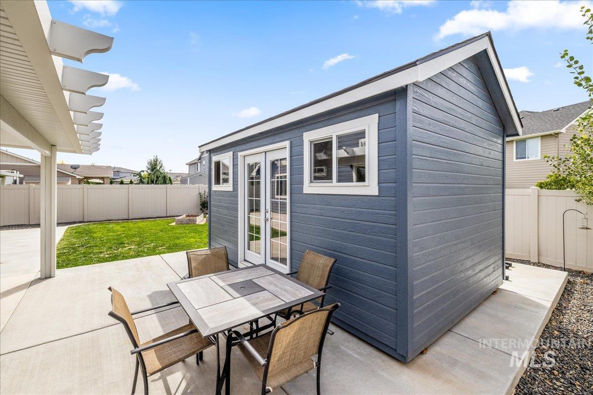 Fenced backyard with an outbuilding, a patio area, and french doors