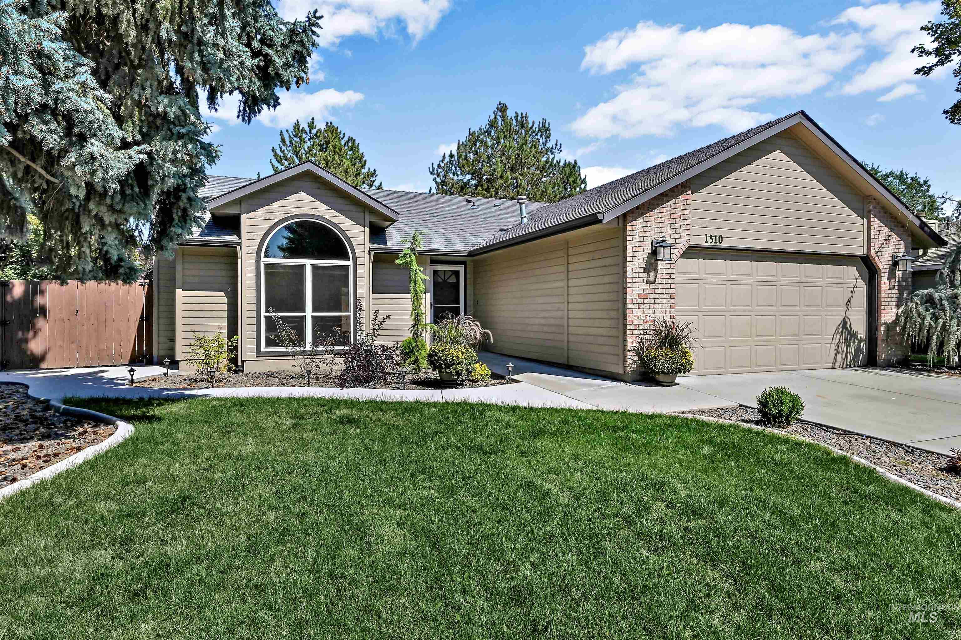 Ranch-style house with an attached garage, concrete driveway, and brick siding