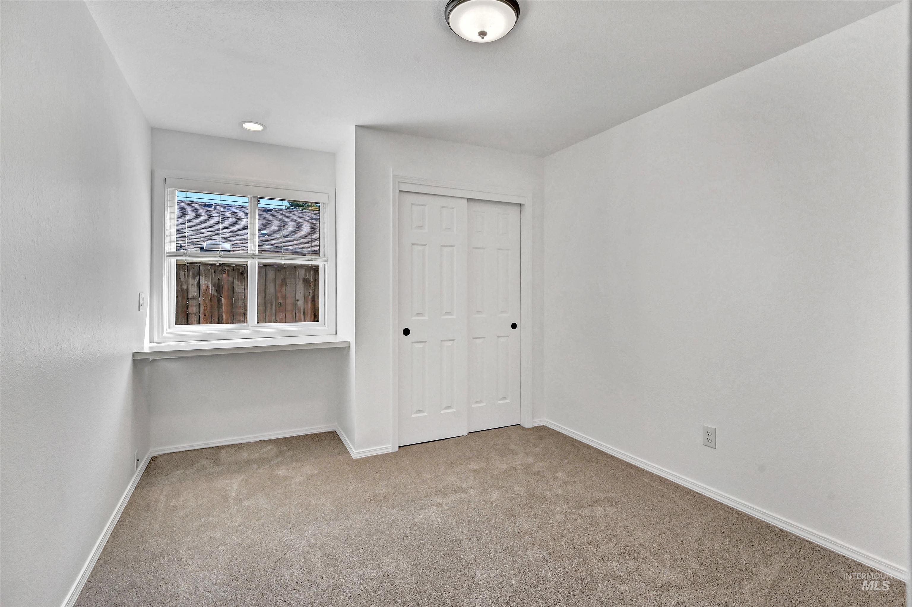 Unfurnished bedroom with light colored carpet and a closet
