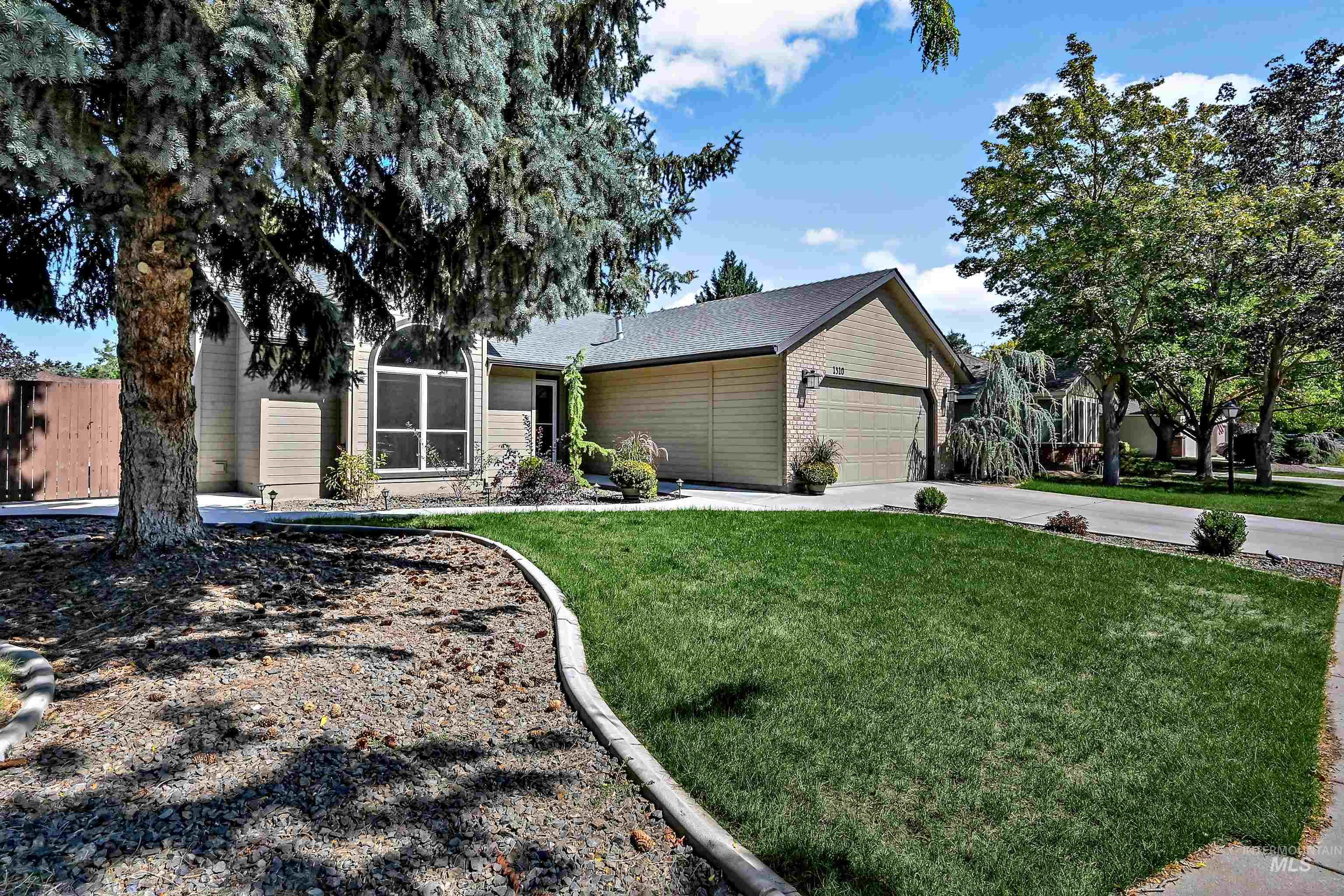 View of front of home with driveway, a garage, a front lawn, and brick siding