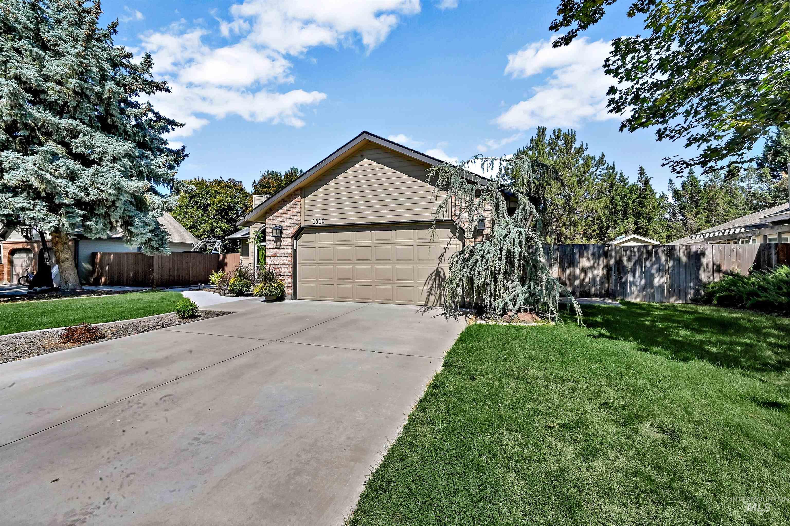 View of front of home featuring concrete driveway, a garage, and brick siding