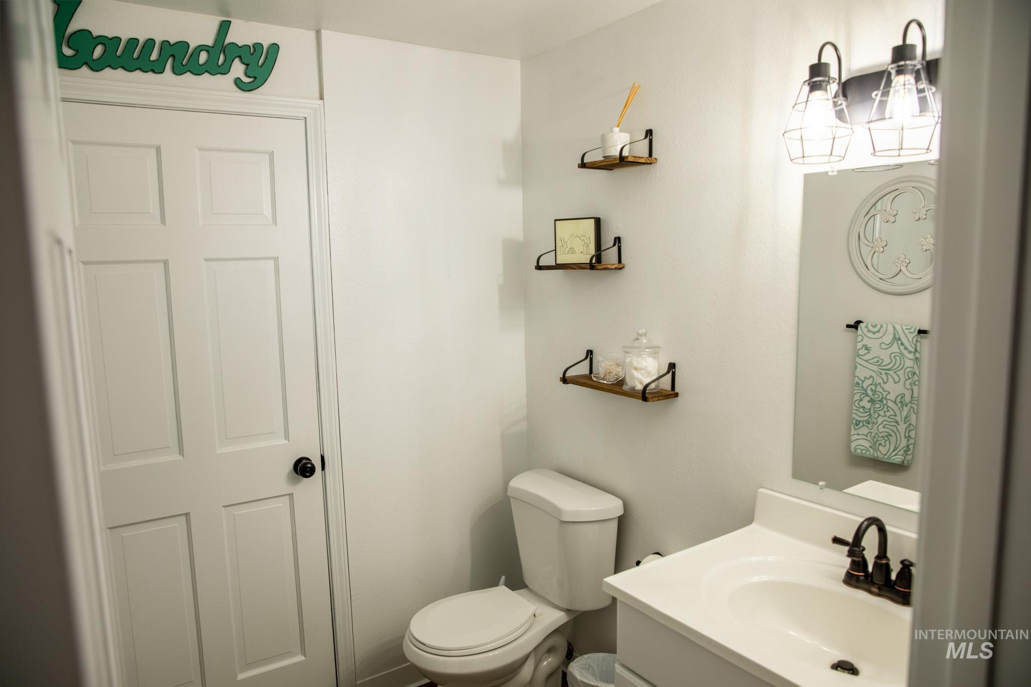 Half bathroom featuring vanity and toilet