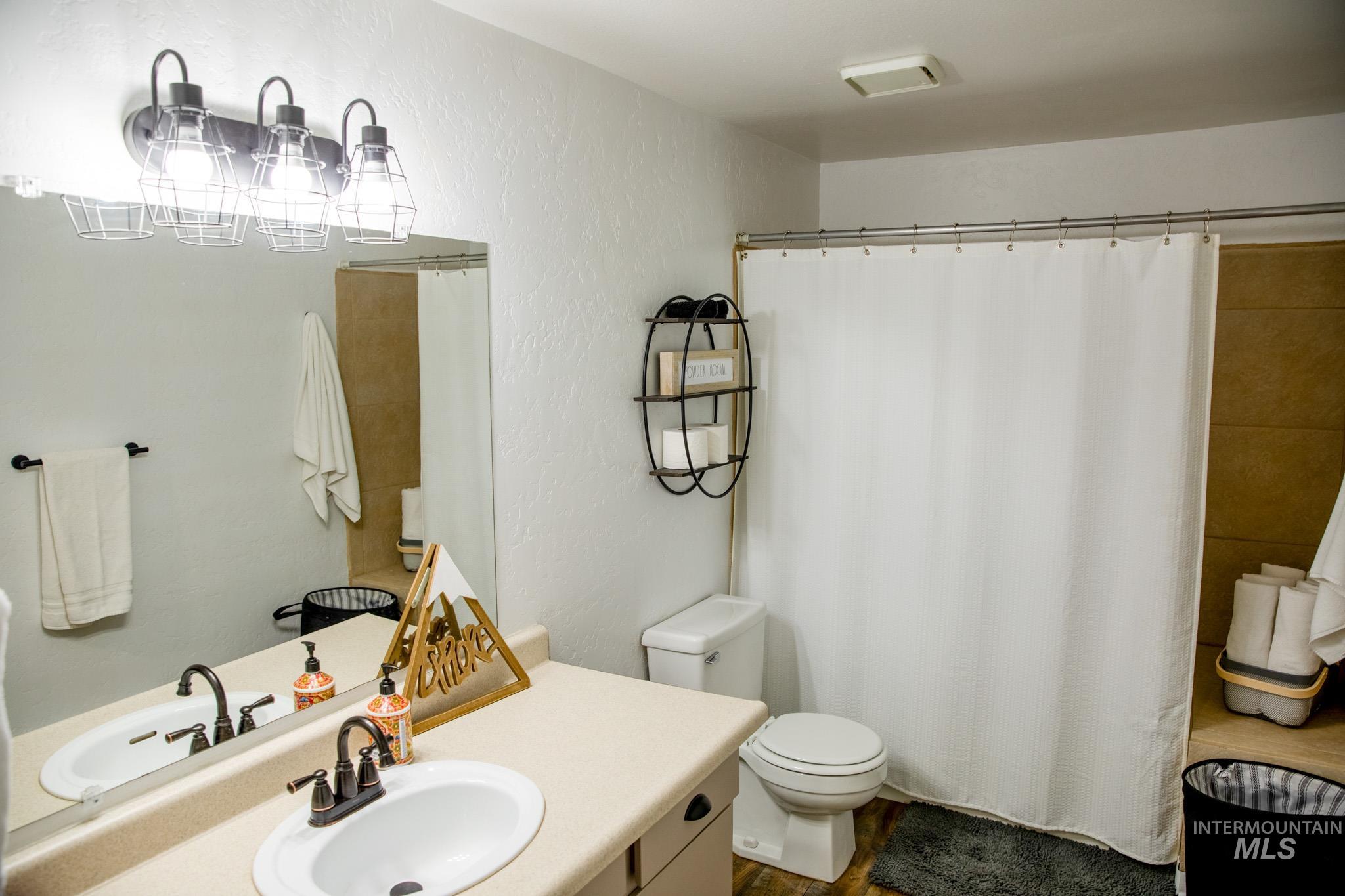 Bathroom with vanity, a textured wall, and curtained shower