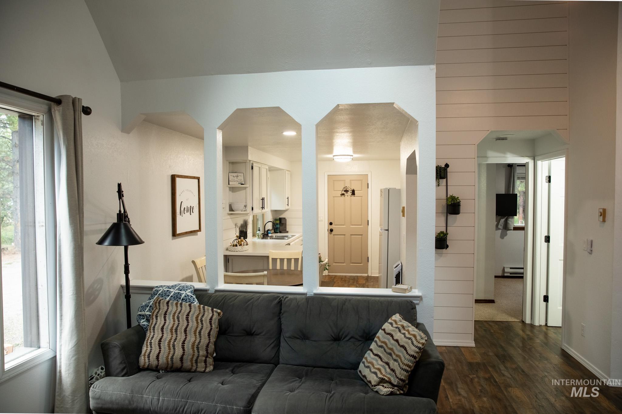 Living room featuring dark wood finished floors and baseboards