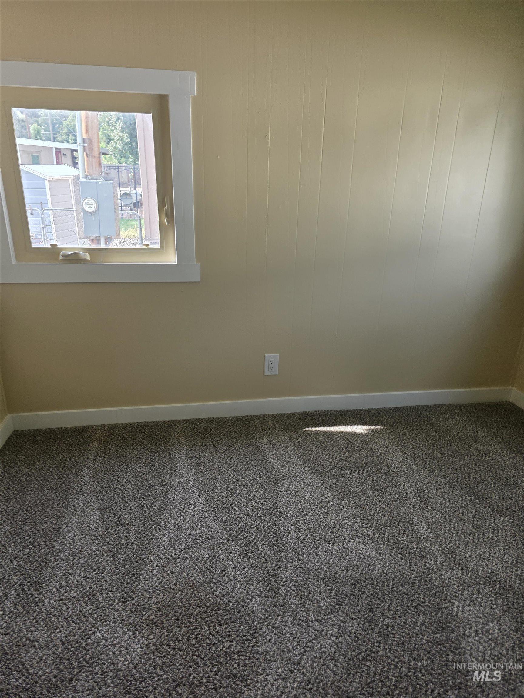 Carpeted empty room with baseboards