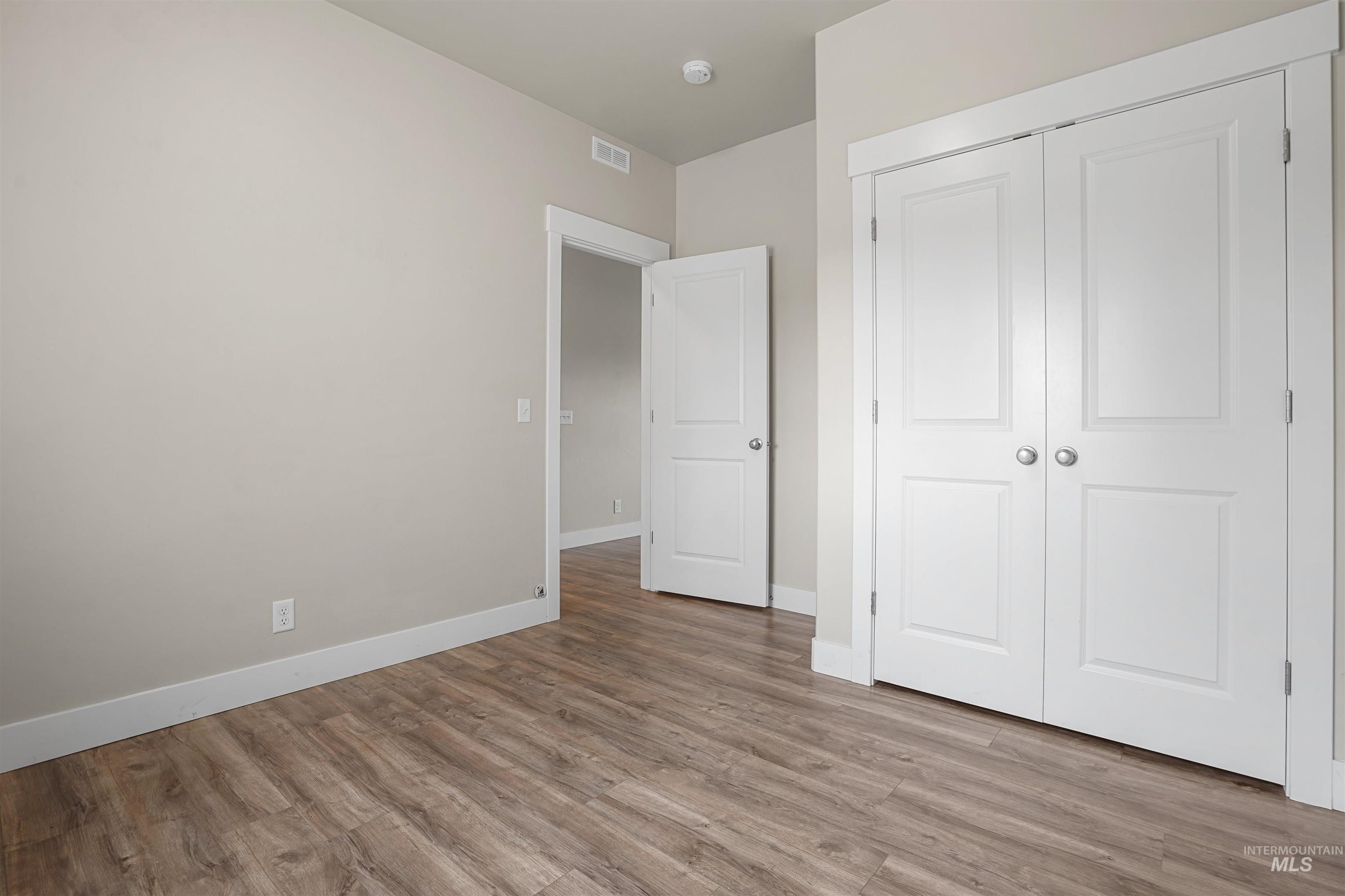Unfurnished bedroom featuring light wood-style floors and a closet