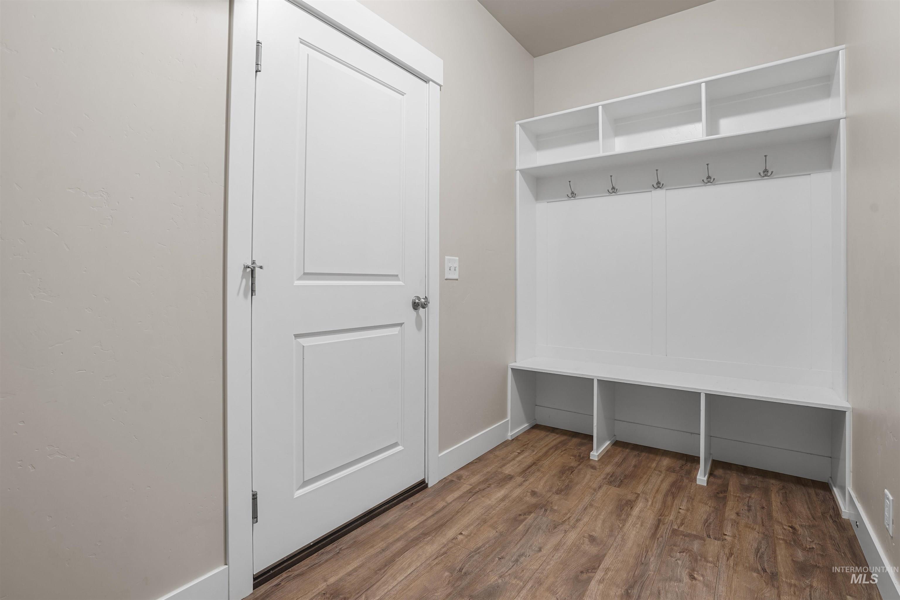 Mudroom featuring dark wood-style flooring and baseboards