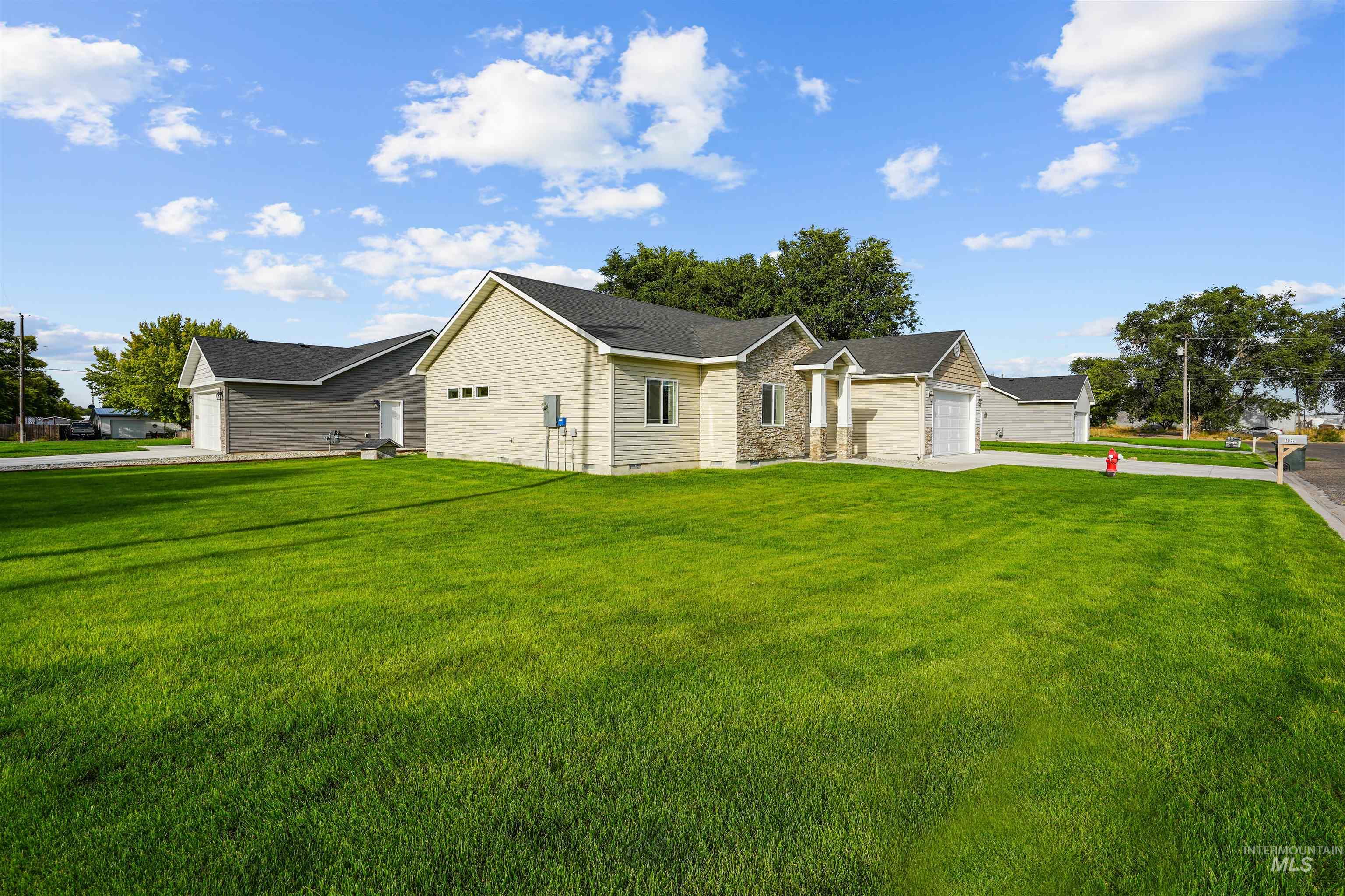 View of front facade featuring a front lawn, concrete driveway, and a garage
