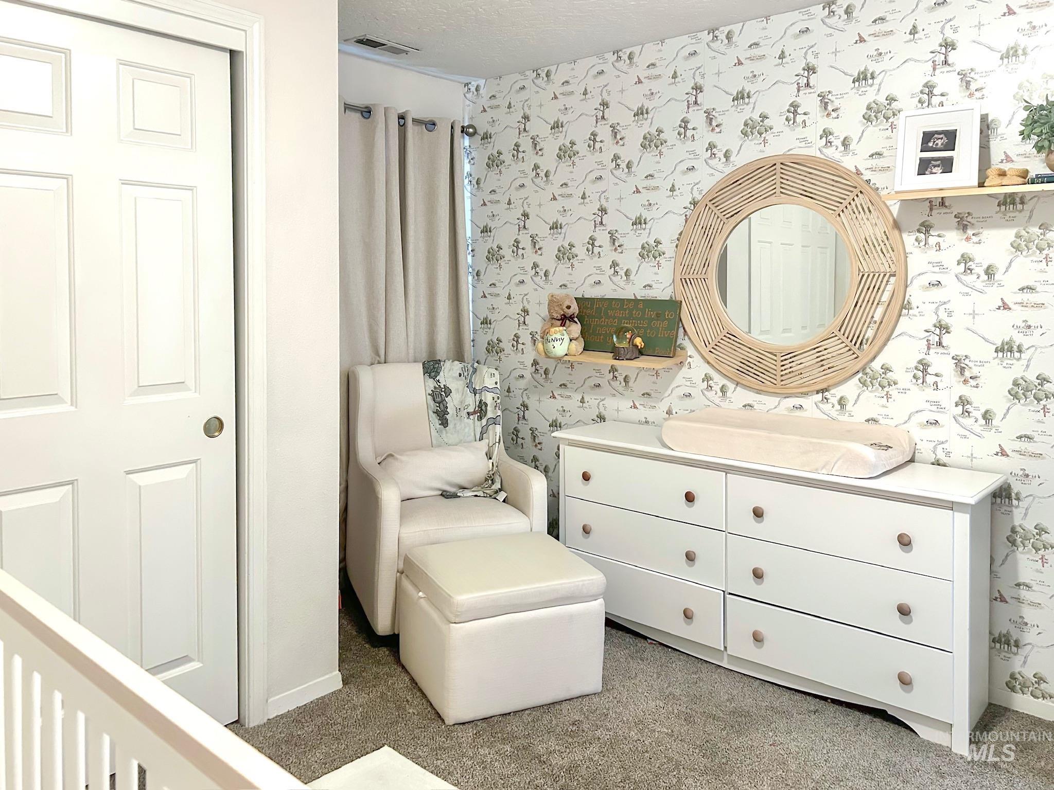 Living area featuring wallpapered walls and a textured ceiling