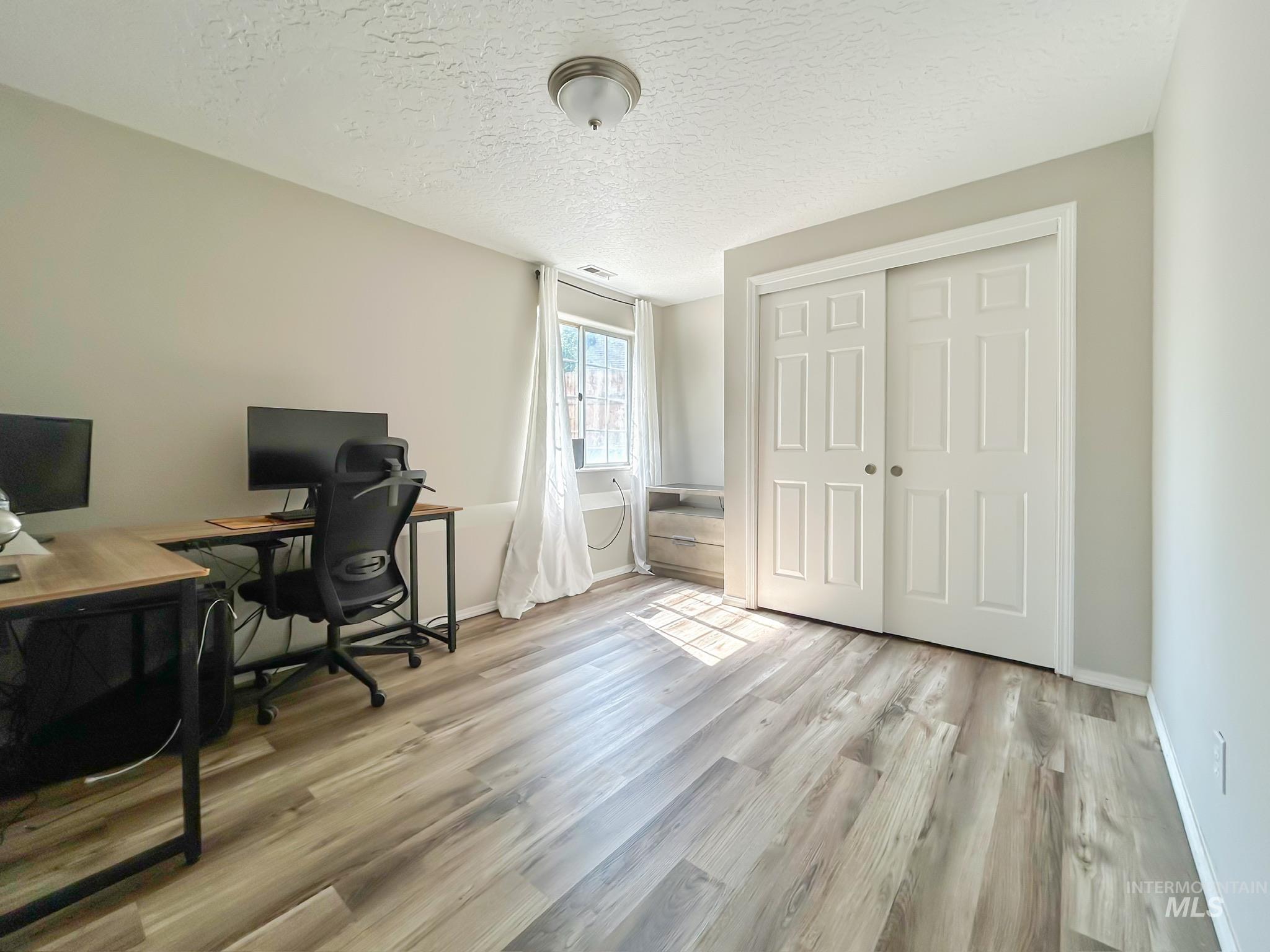 Office featuring a textured ceiling and light wood finished floors