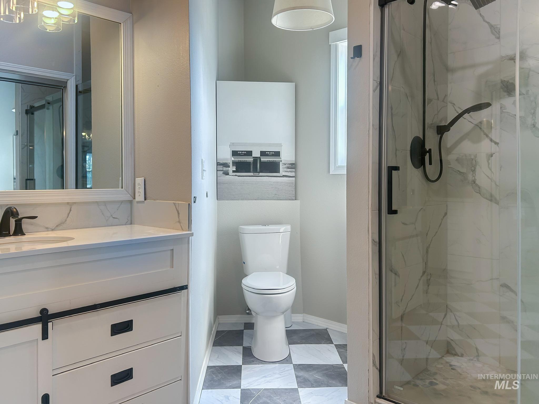 Full bathroom featuring a marble finish shower and vanity