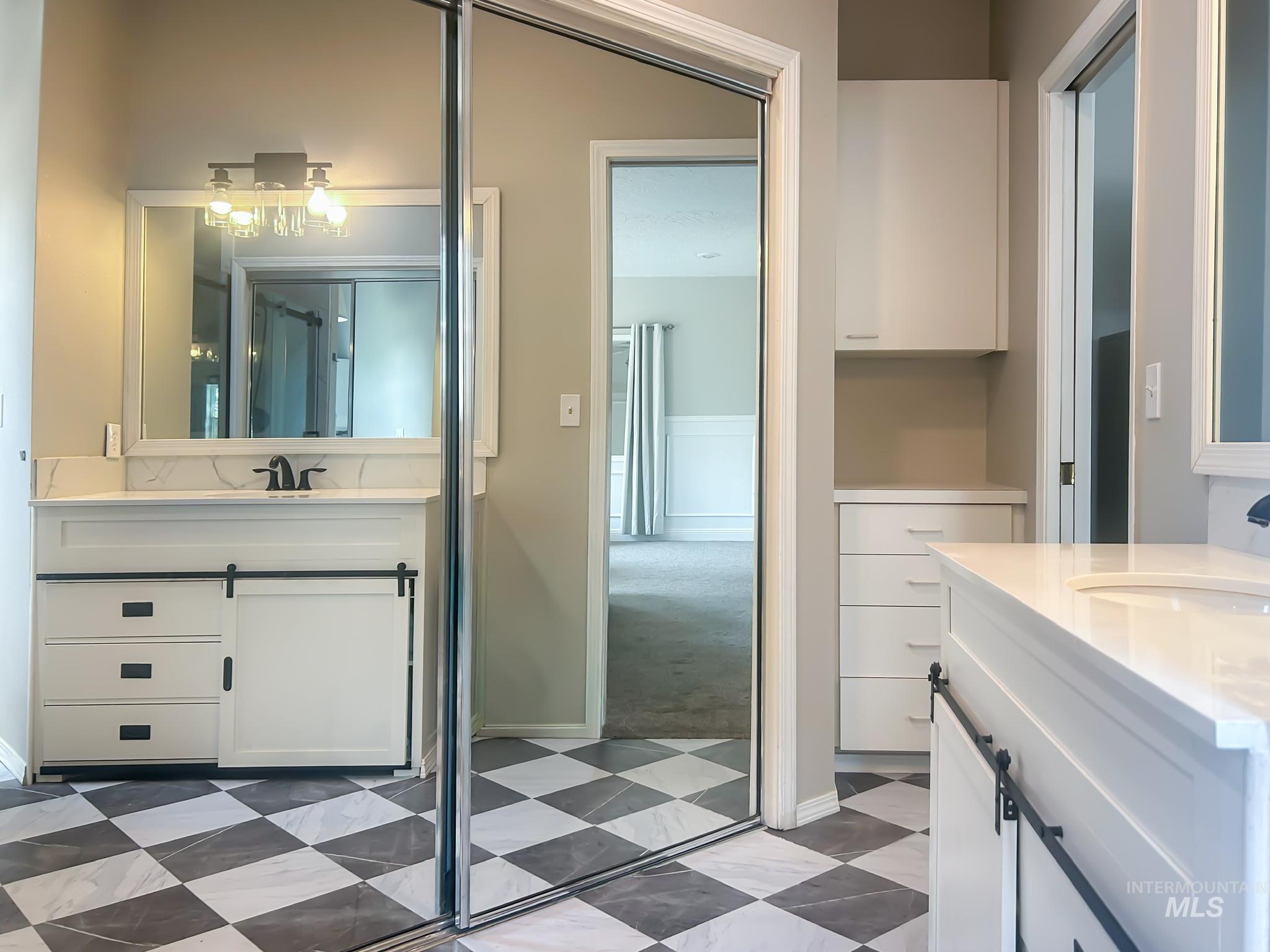 Full bathroom with two vanities and baseboards