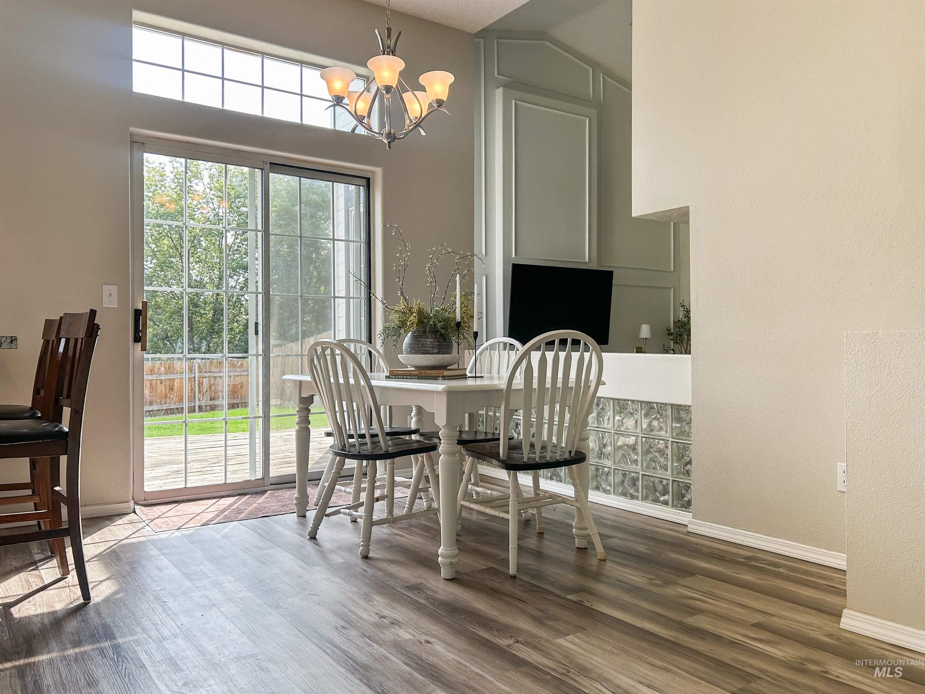Dining area featuring a chandelier, dark wood-style flooring, and a towering ceiling